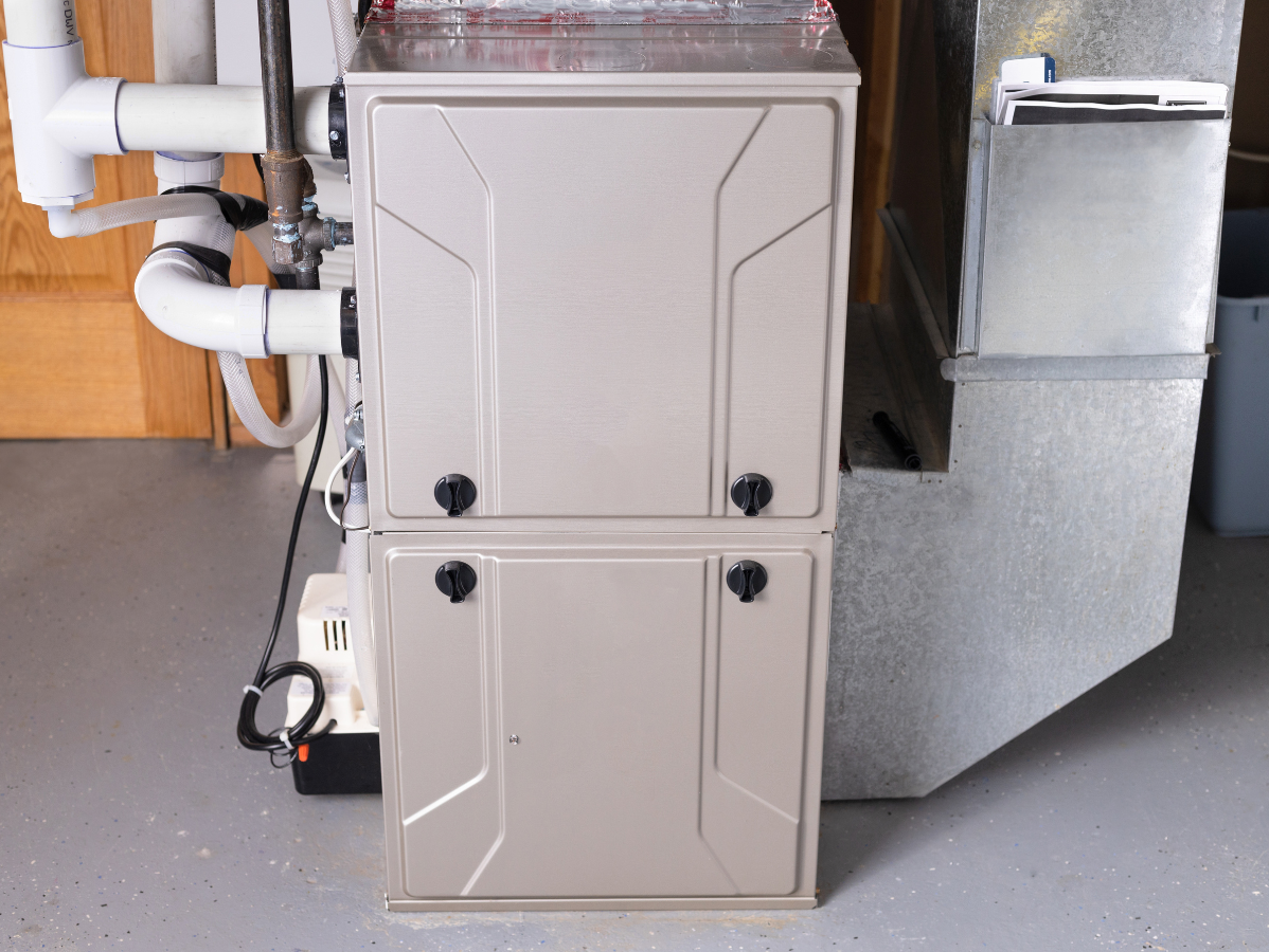 Gray furnace and ductwork in a basement utility room