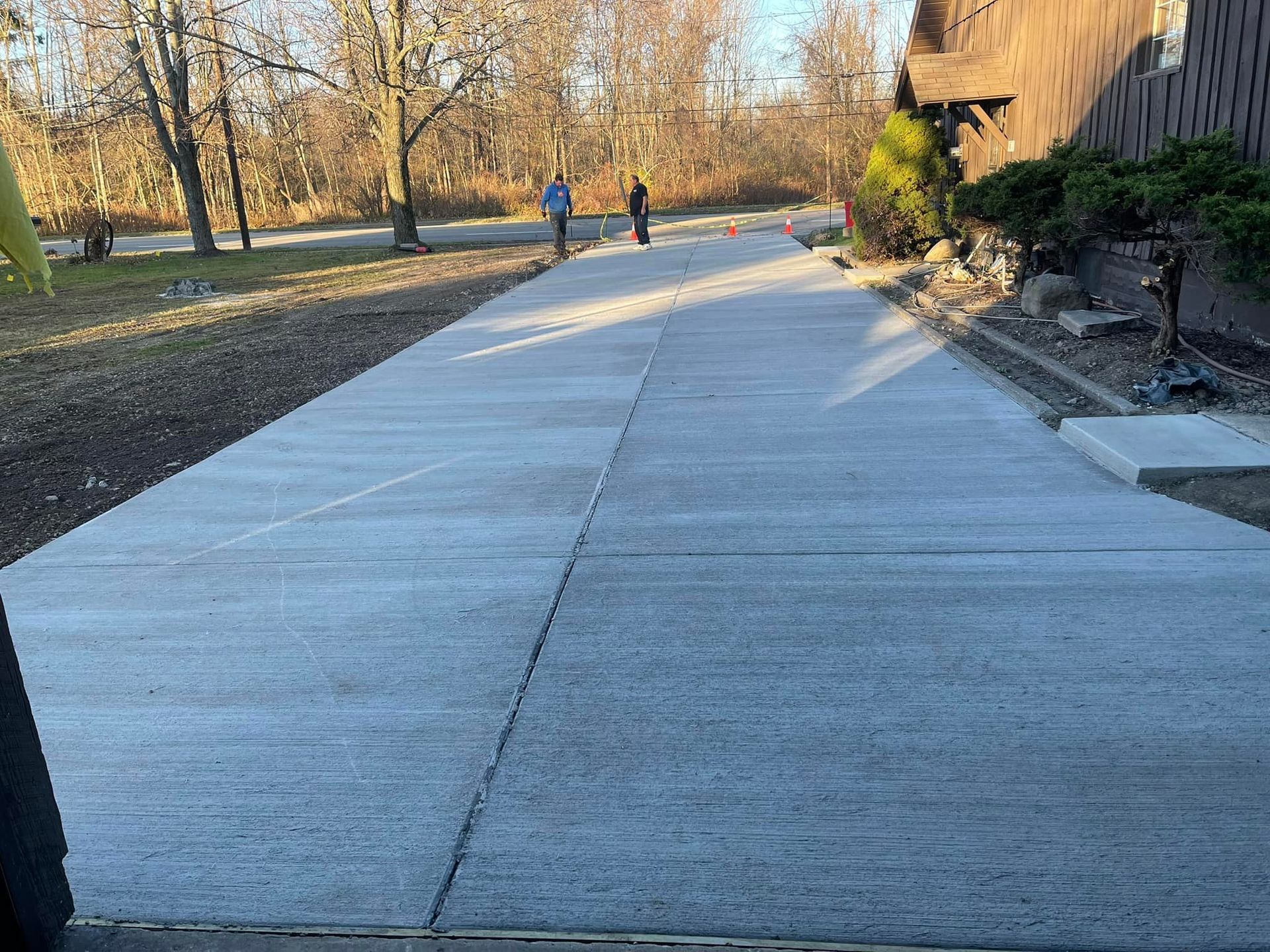 A brick walkway in a park surrounded by trees and bushes.