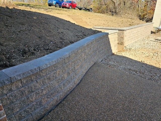 A pile of rocks in a yard with a house in the background