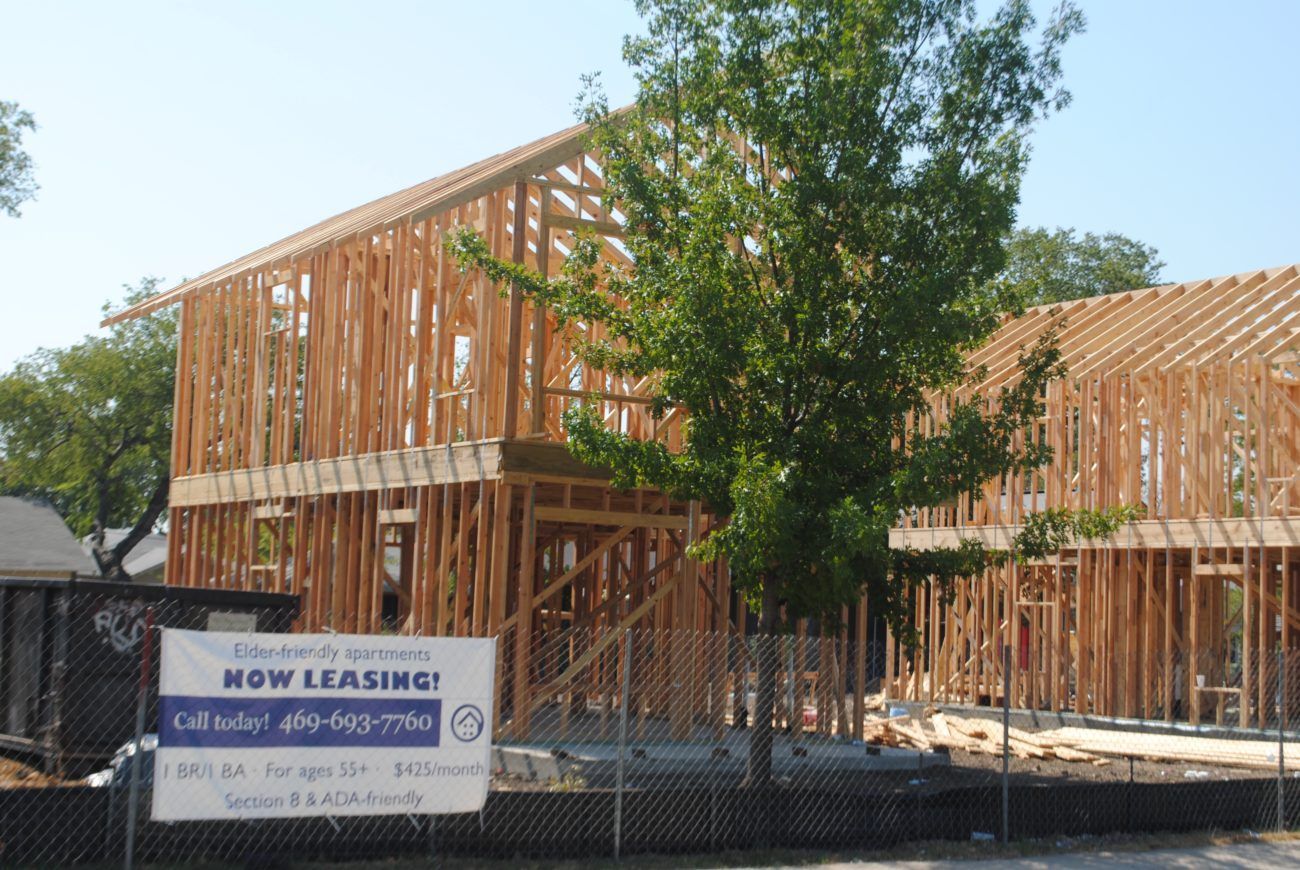 A building under construction with a sign that says now leasing