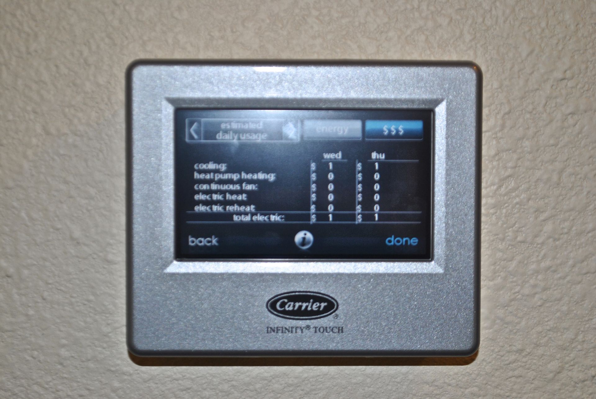 A silver carrier thermostat is mounted on a wall