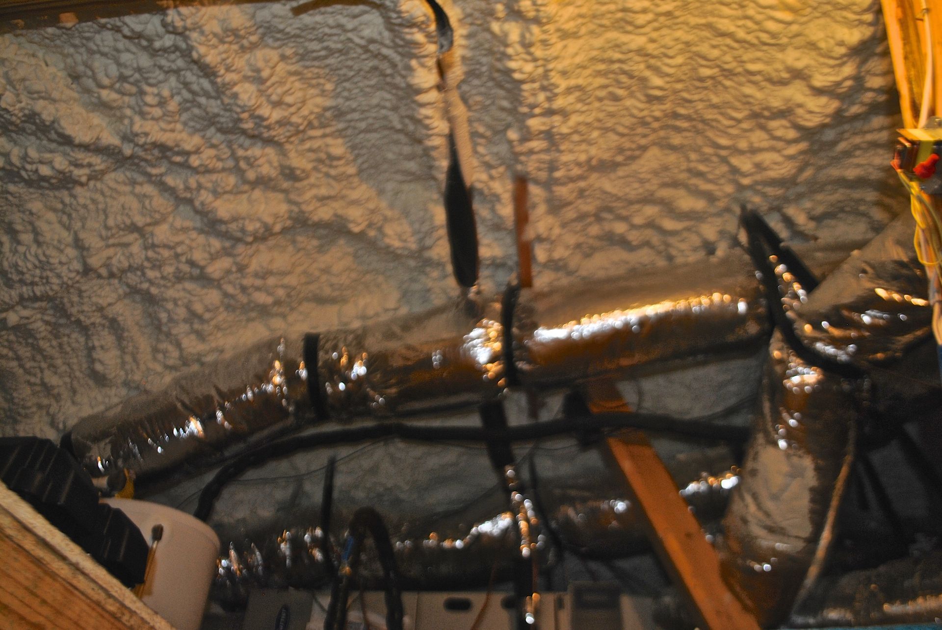 A bunch of pipes are hanging from the ceiling of a building.