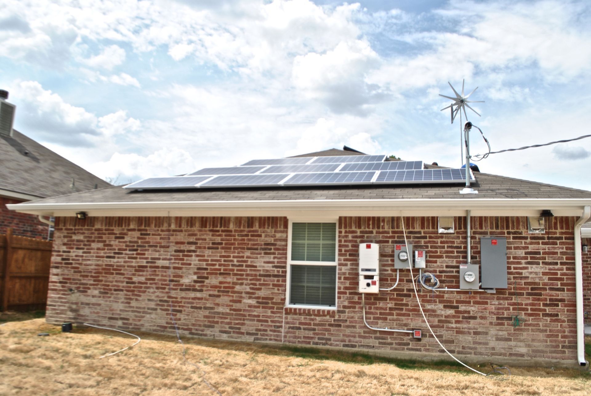 A brick house with solar panels on the roof.