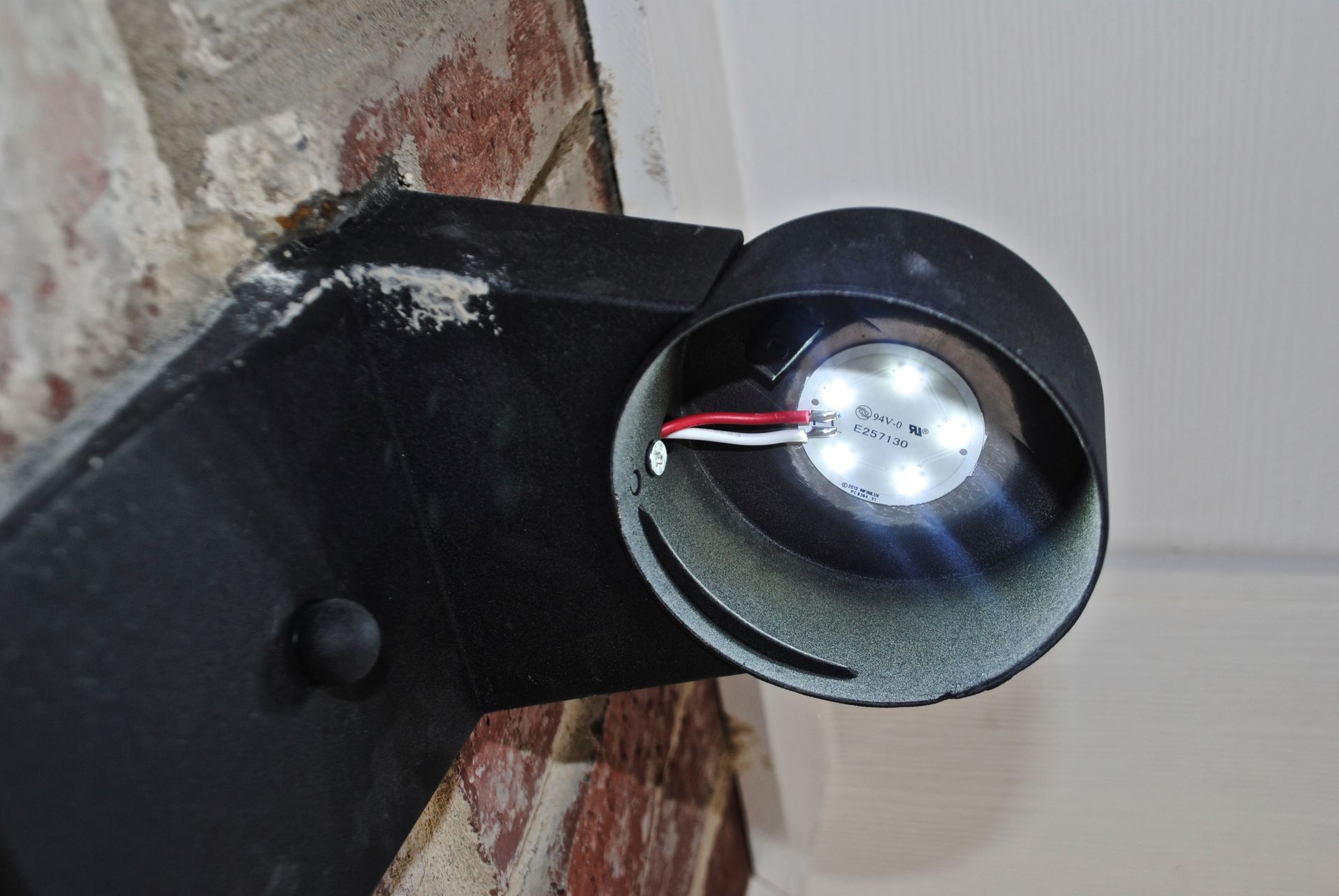 A close up of a light on a brick wall