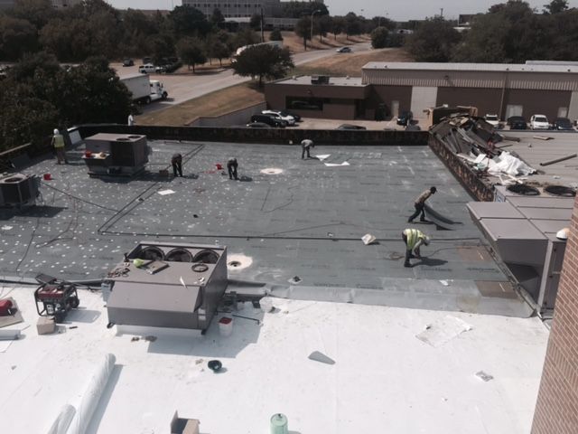 A group of people are working on the roof of a building