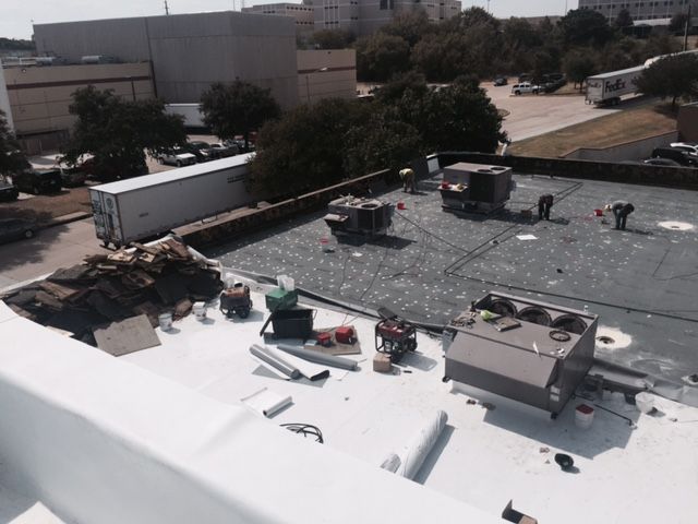 A group of people are working on the roof of a building