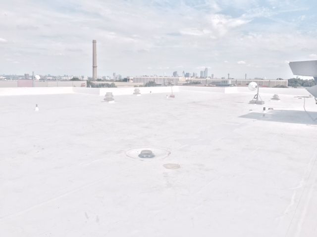 A plane is sitting on top of a white roof.