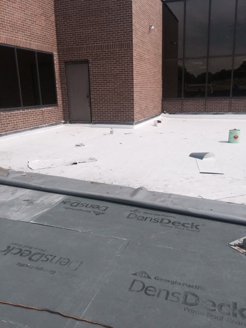 A large brick building with a roof that is being installed