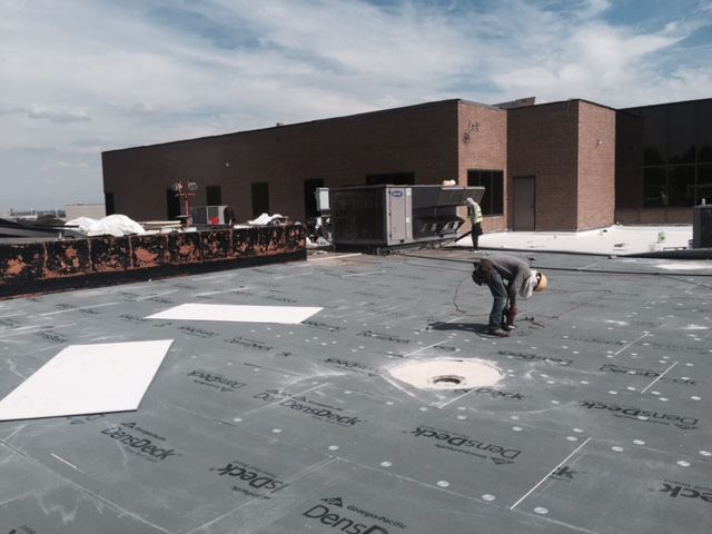 A man is working on the roof of a building