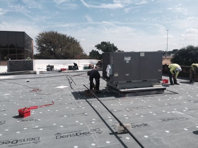 A group of men are working on the roof of a building