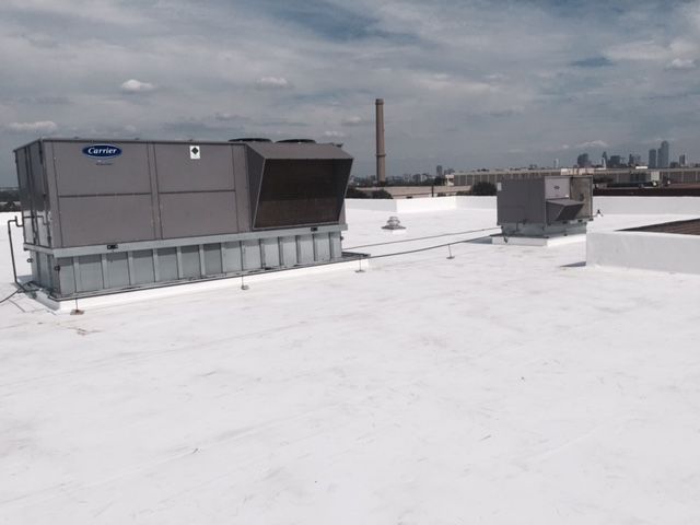 A white roof with a gray box on top of it.