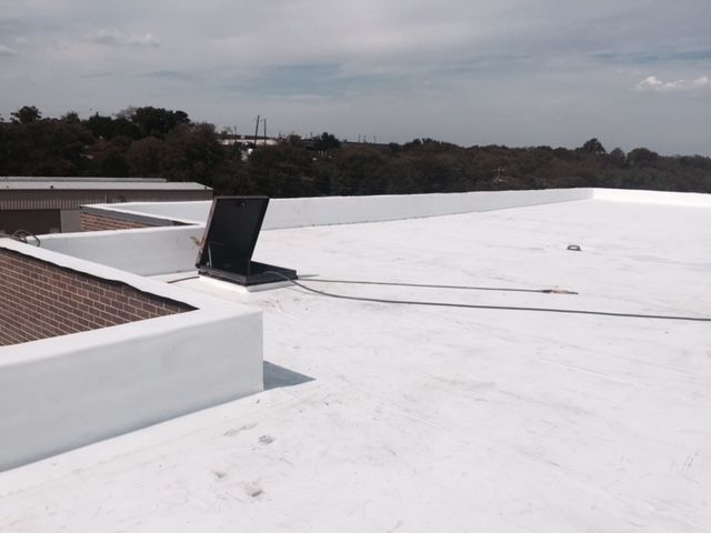A white roof with trees in the background