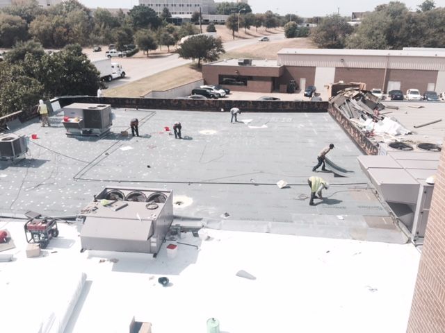 A group of people are working on the roof of a building
