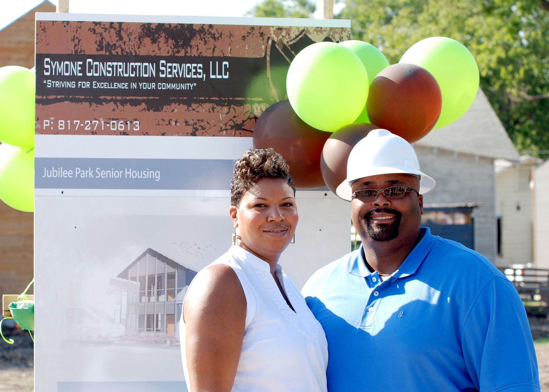 A man and woman standing in front of a sign that says smoke construction service llc