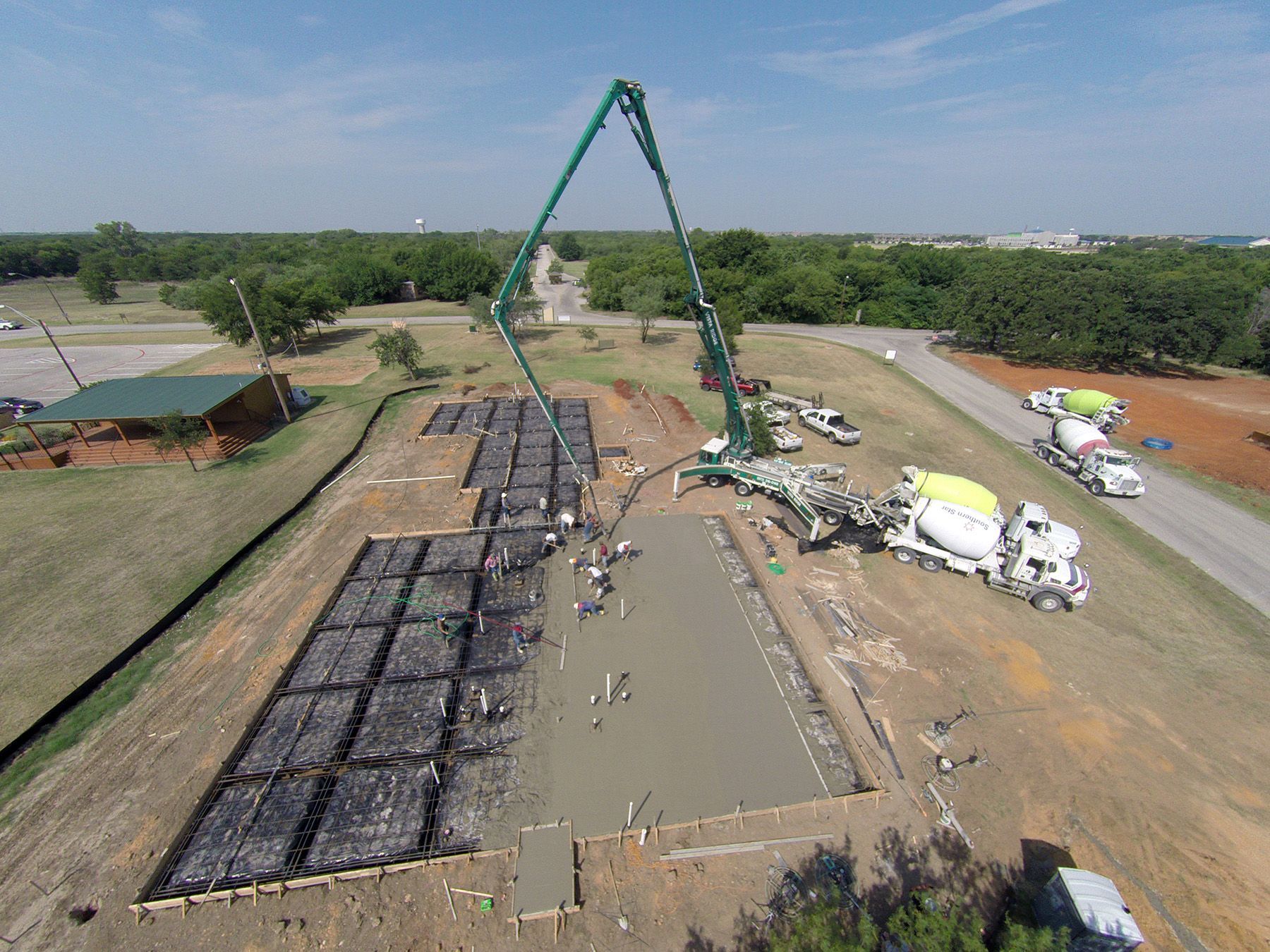 An aerial view of a concrete pump pouring concrete on a construction site.