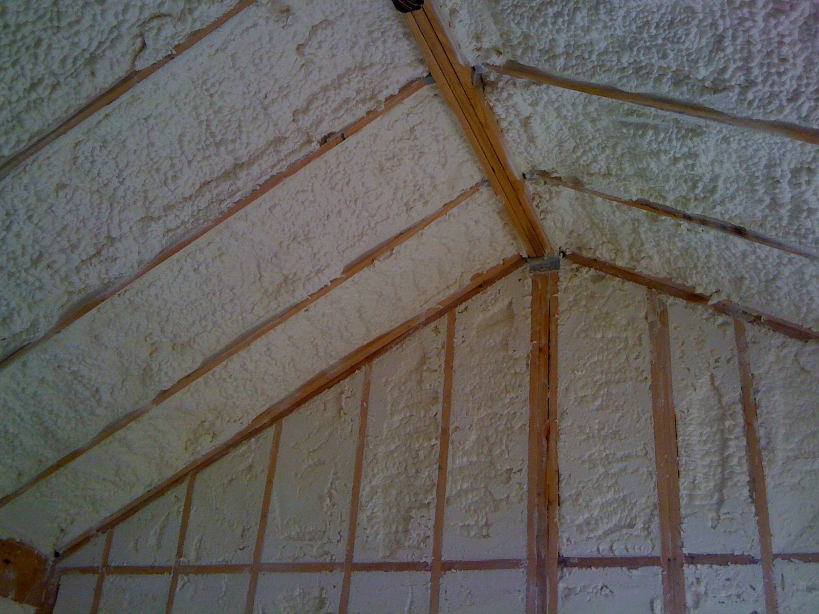 A room with a vaulted ceiling and walls covered in spray foam.