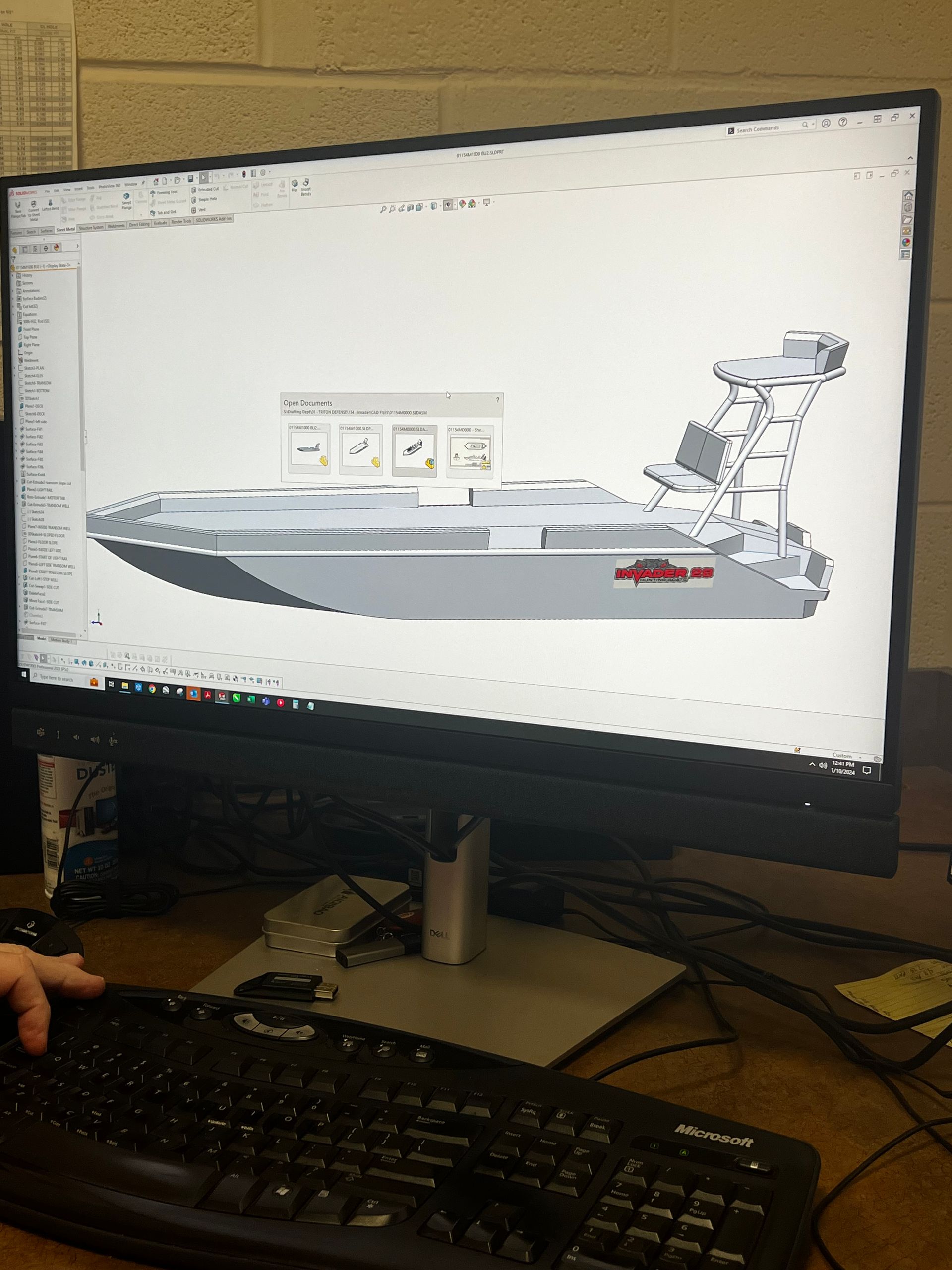A computer monitor shows a 3D model of a boat