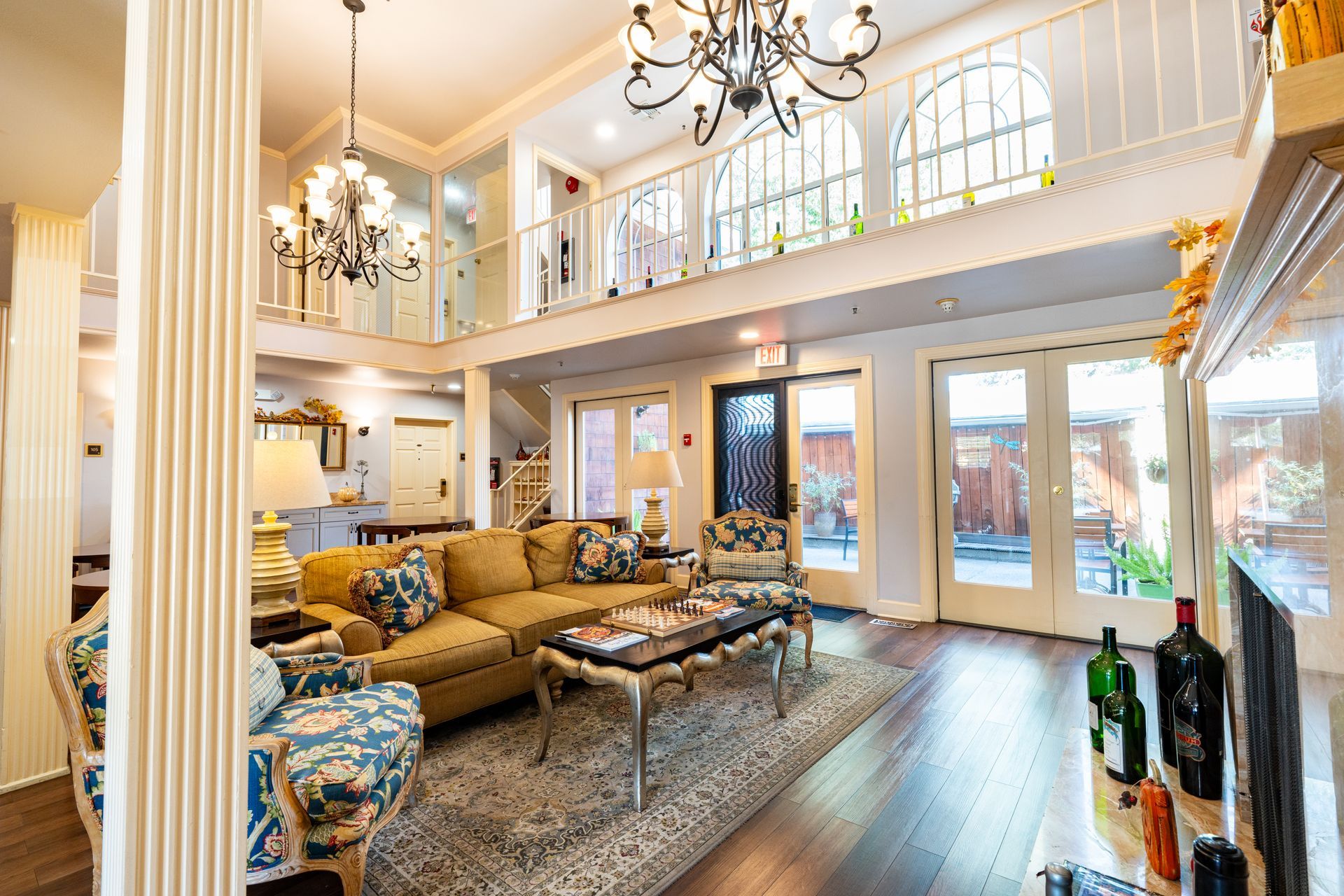 Bright, ornate living room with a two-story layout, chandelier, and a balcony.