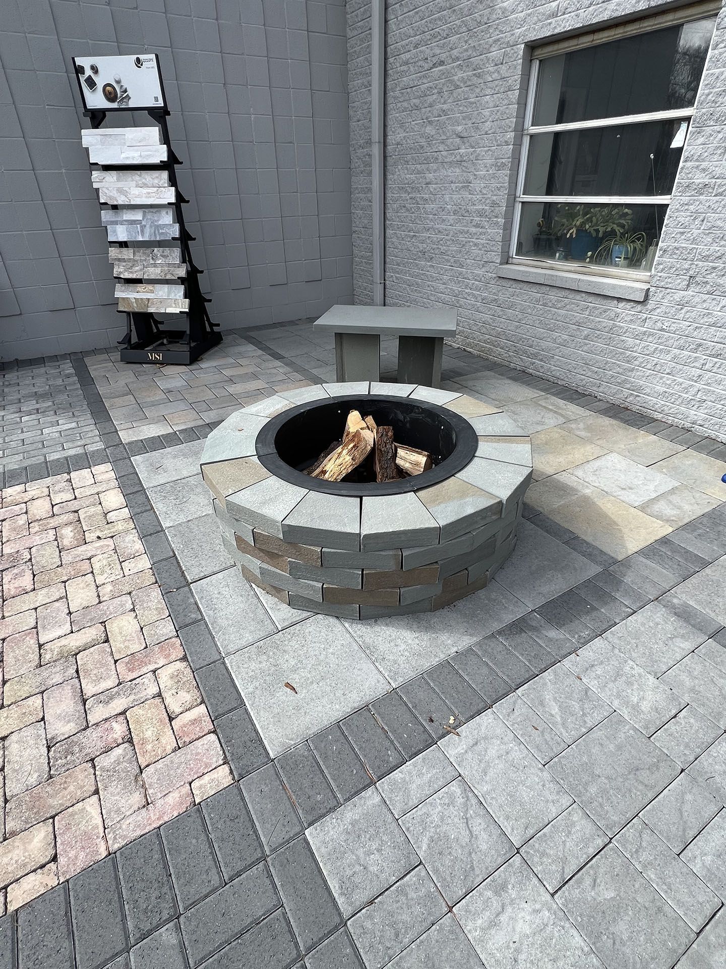 A fire pit with logs in it on a patio 2