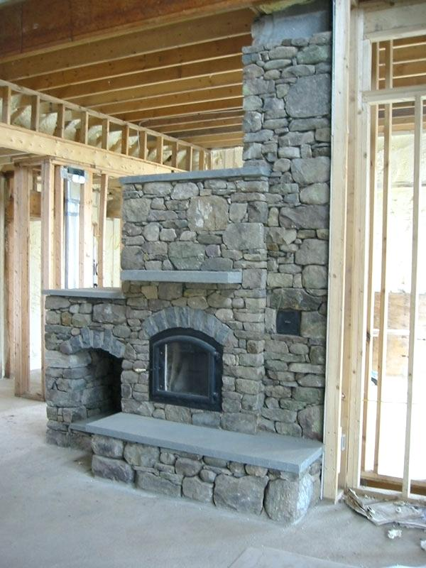 A stone fireplace in a house under construction