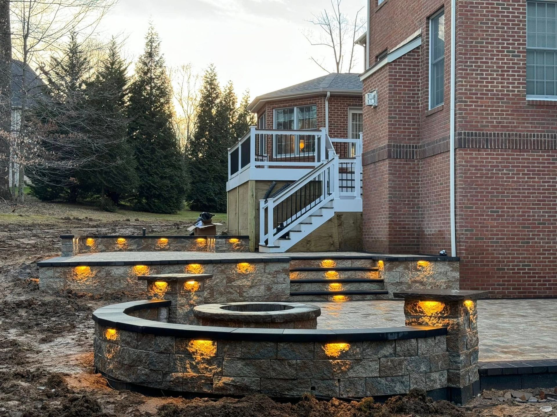 A brick house with a fire pit and stairs in front of it.