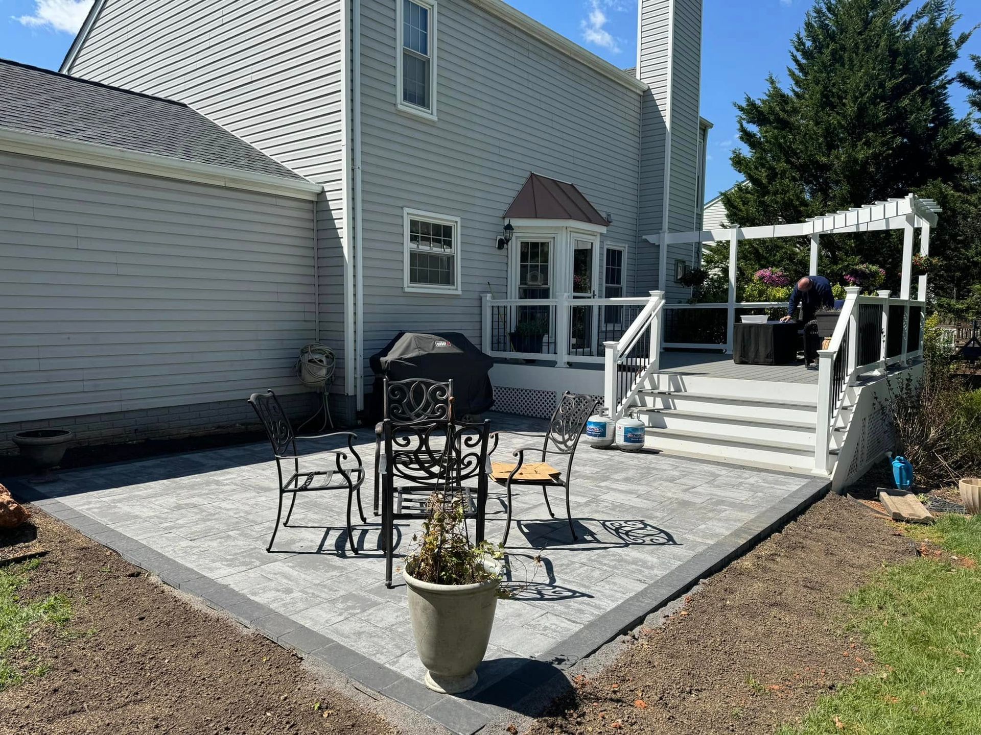 A patio with a table and chairs in front of a house.