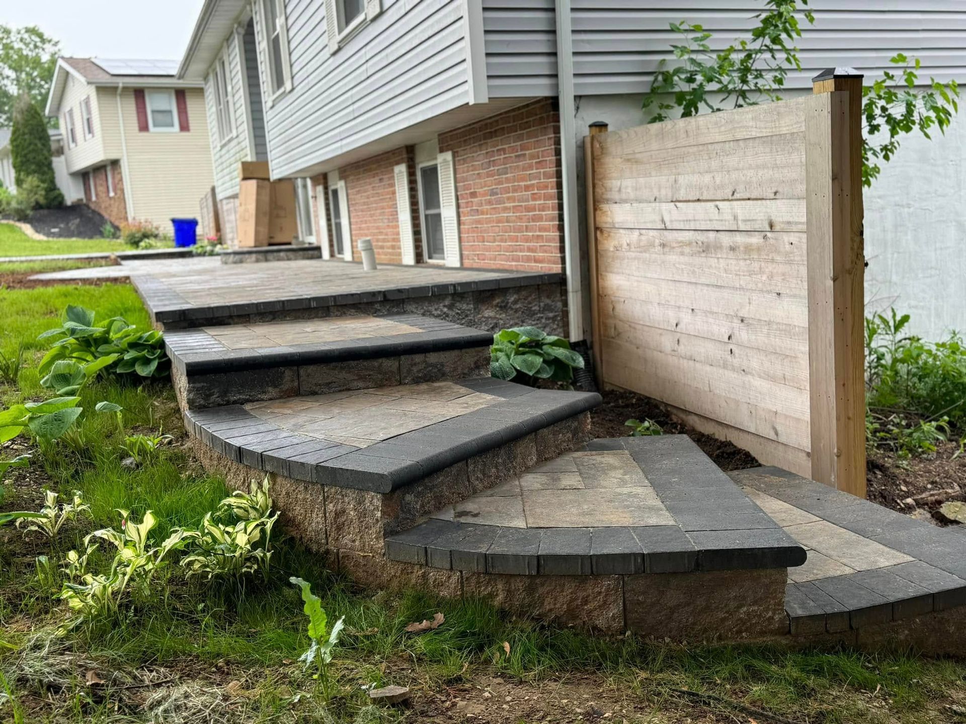 A set of stairs leading up to a patio in front of a house.