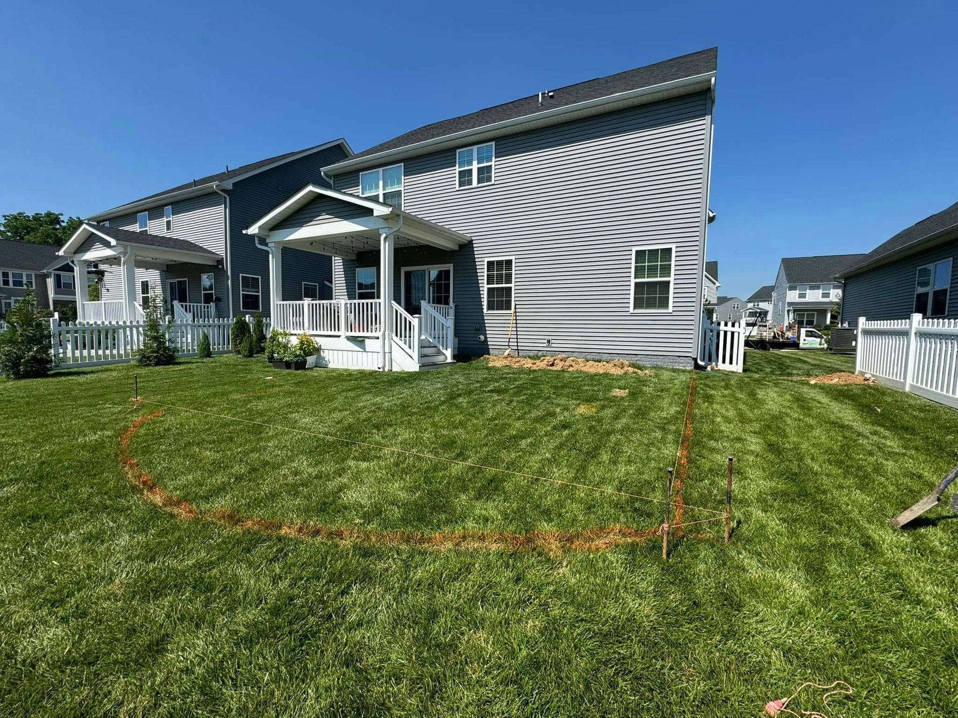 A house with a circle drawn in the grass in front of it.