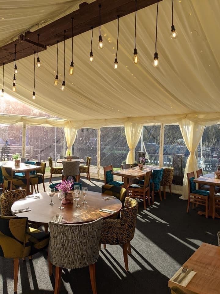 A large room with tables and chairs under a tent