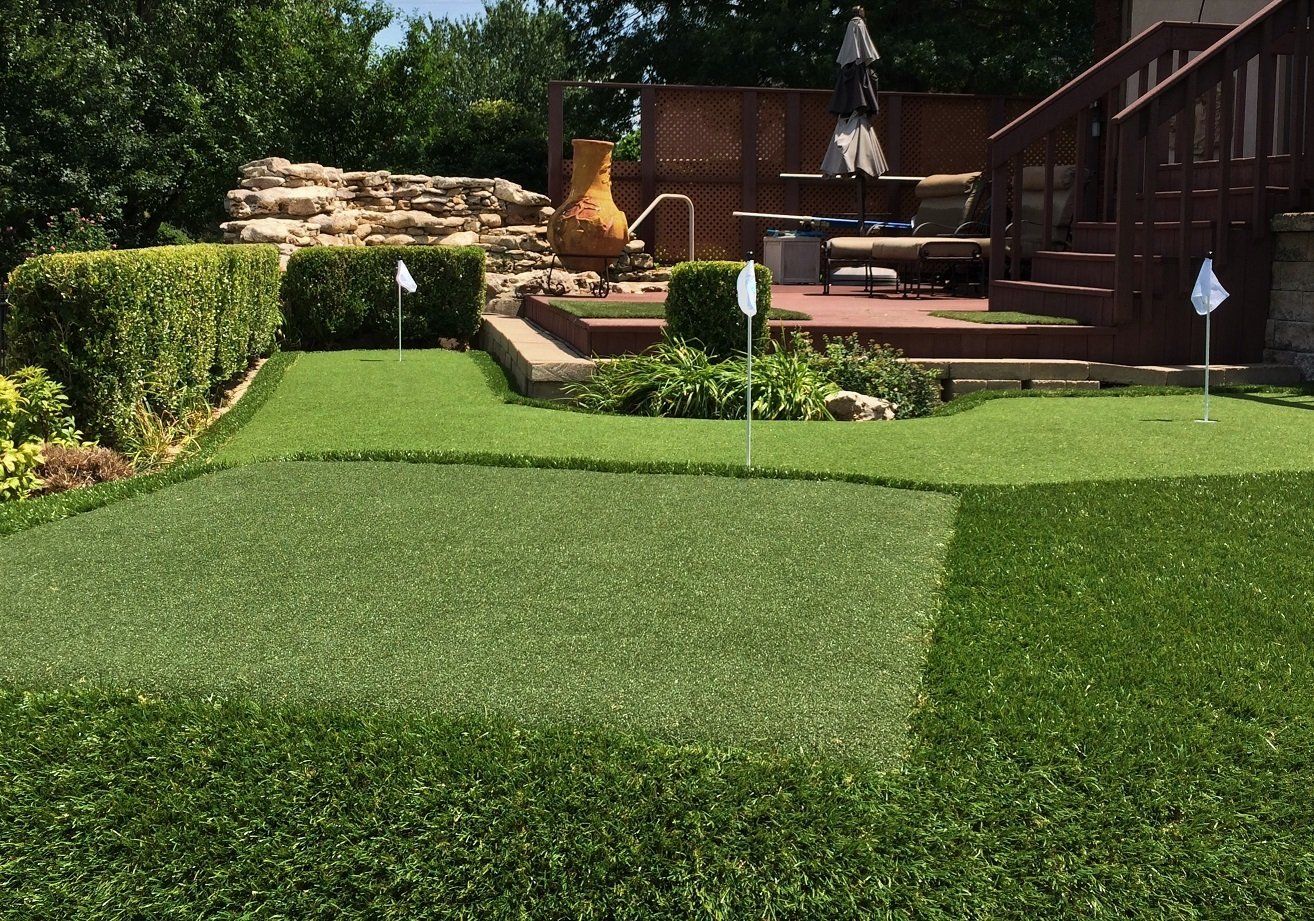 Retaining wall in back yard with grass and planting