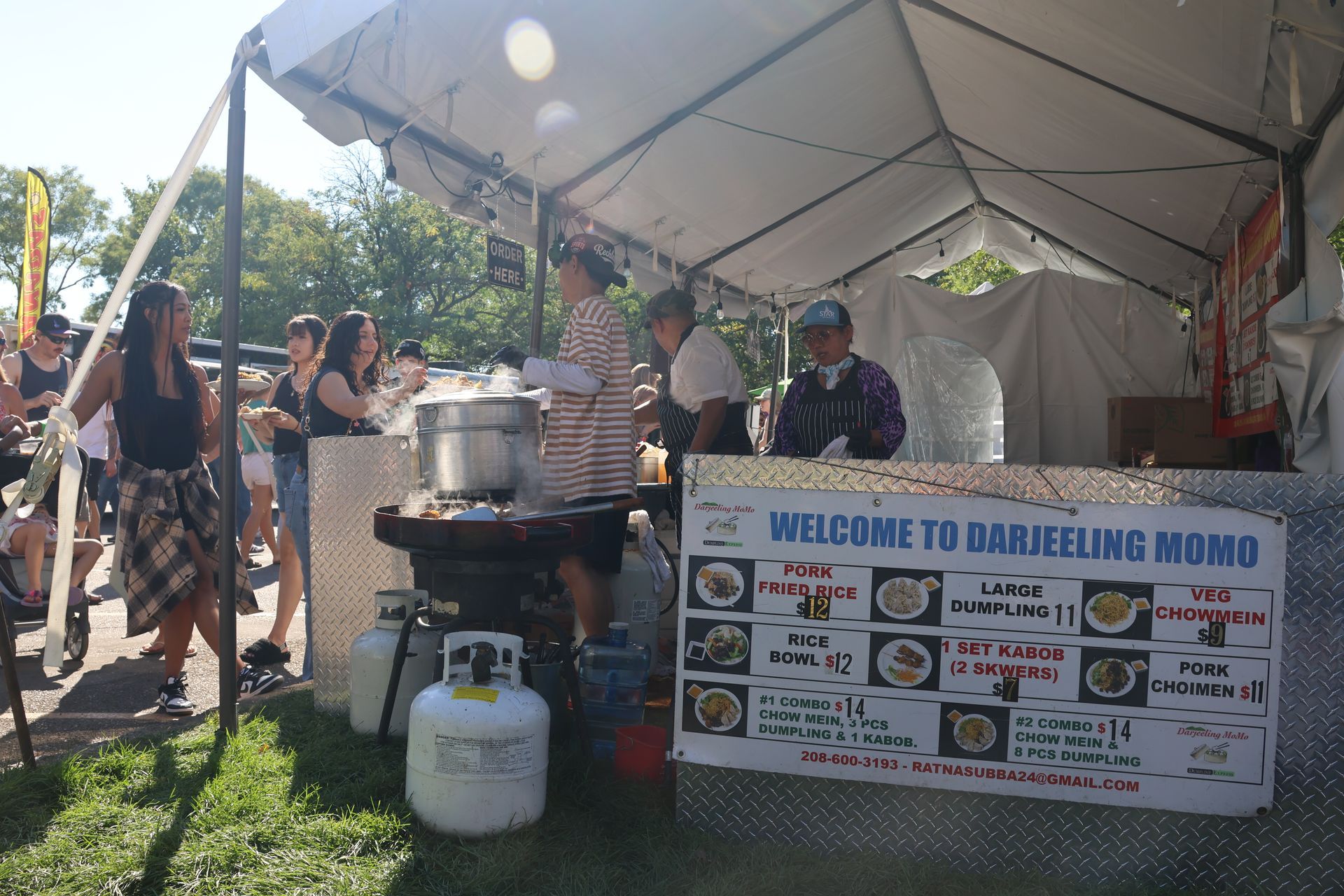 Darjeeling Momo food stall at an outdoor event; people gather.