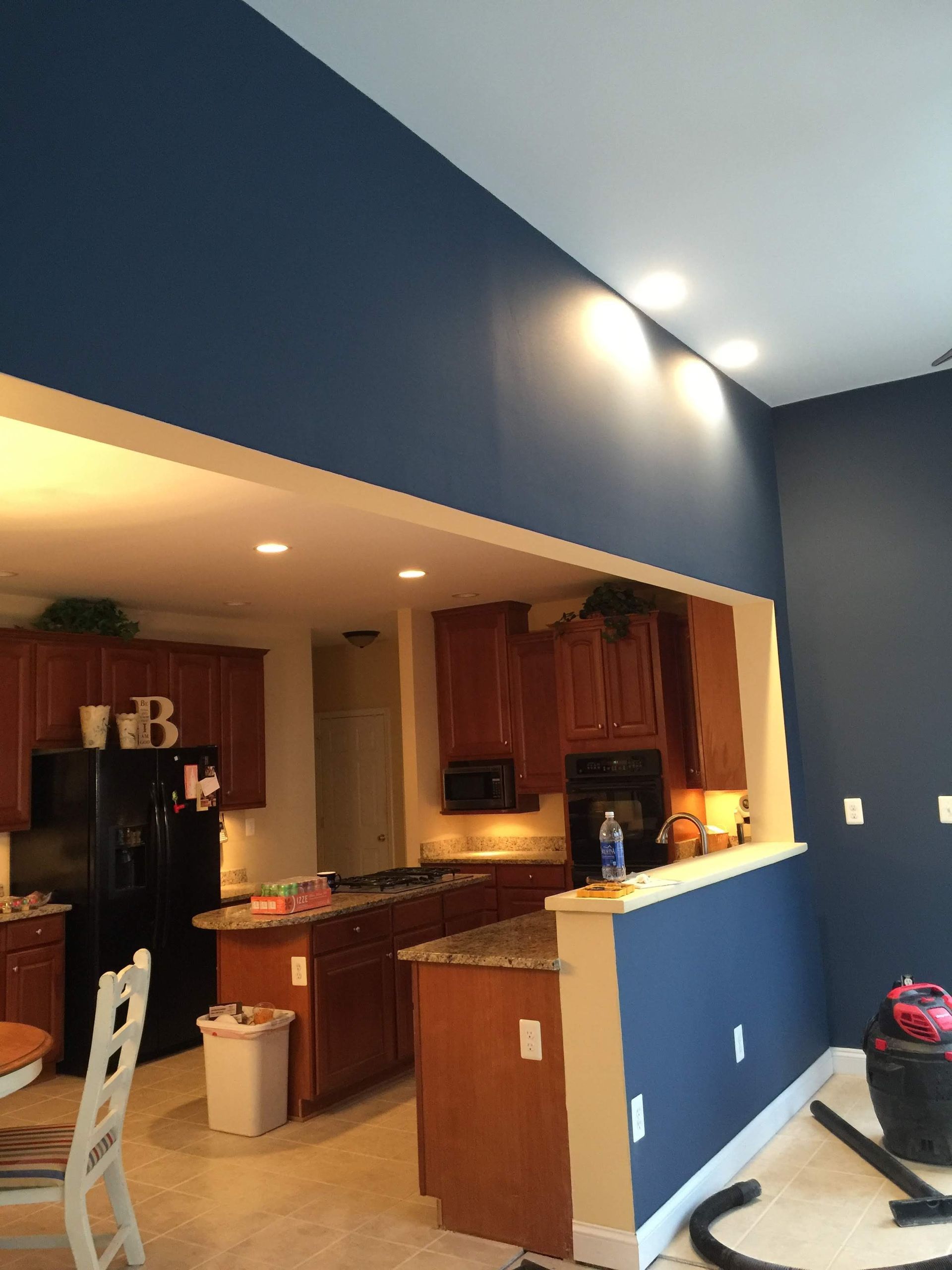 Kitchen with dark blue accent walls and brown cabinets.