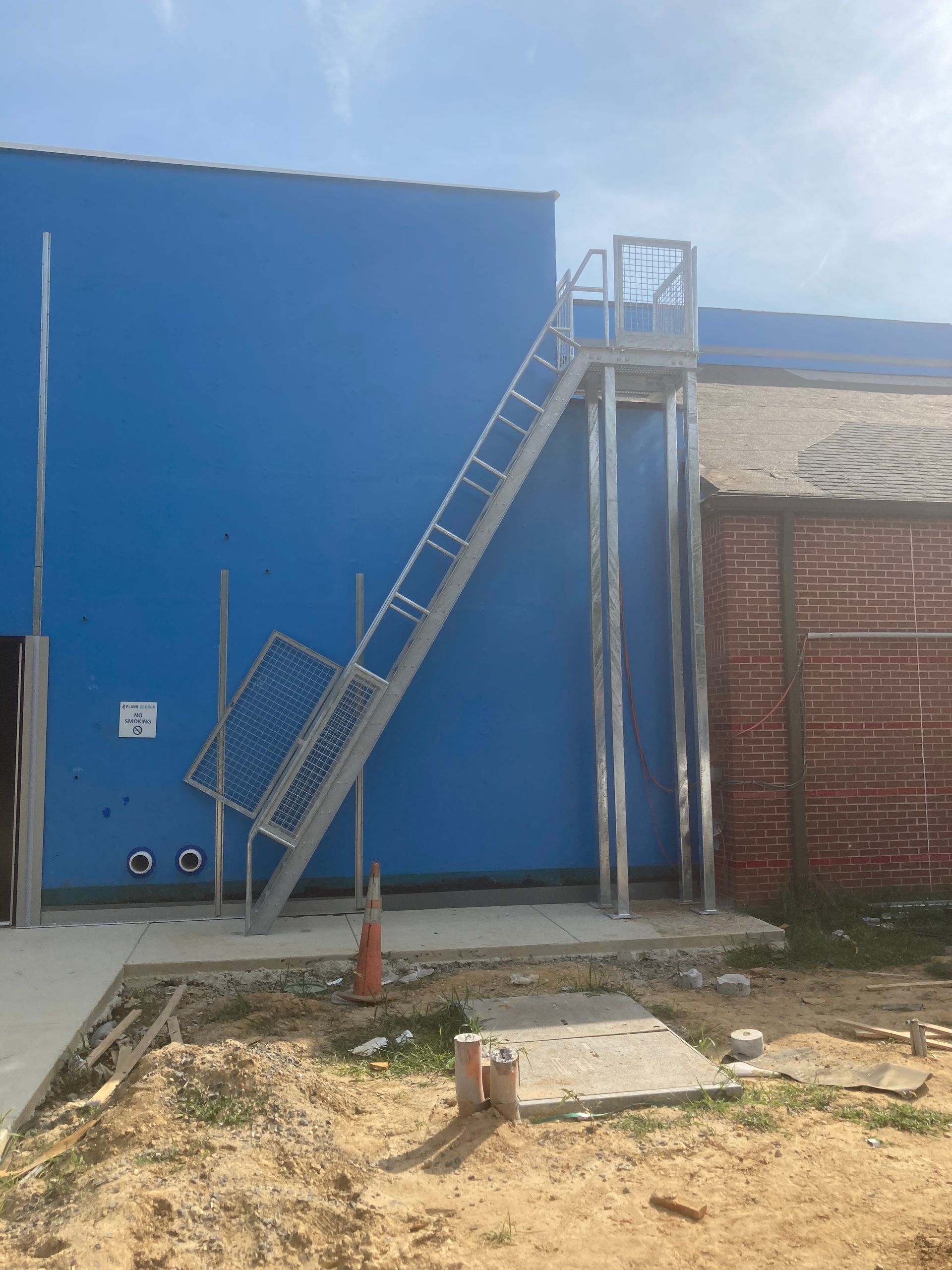 A blue building with a metal staircase on the side of it.