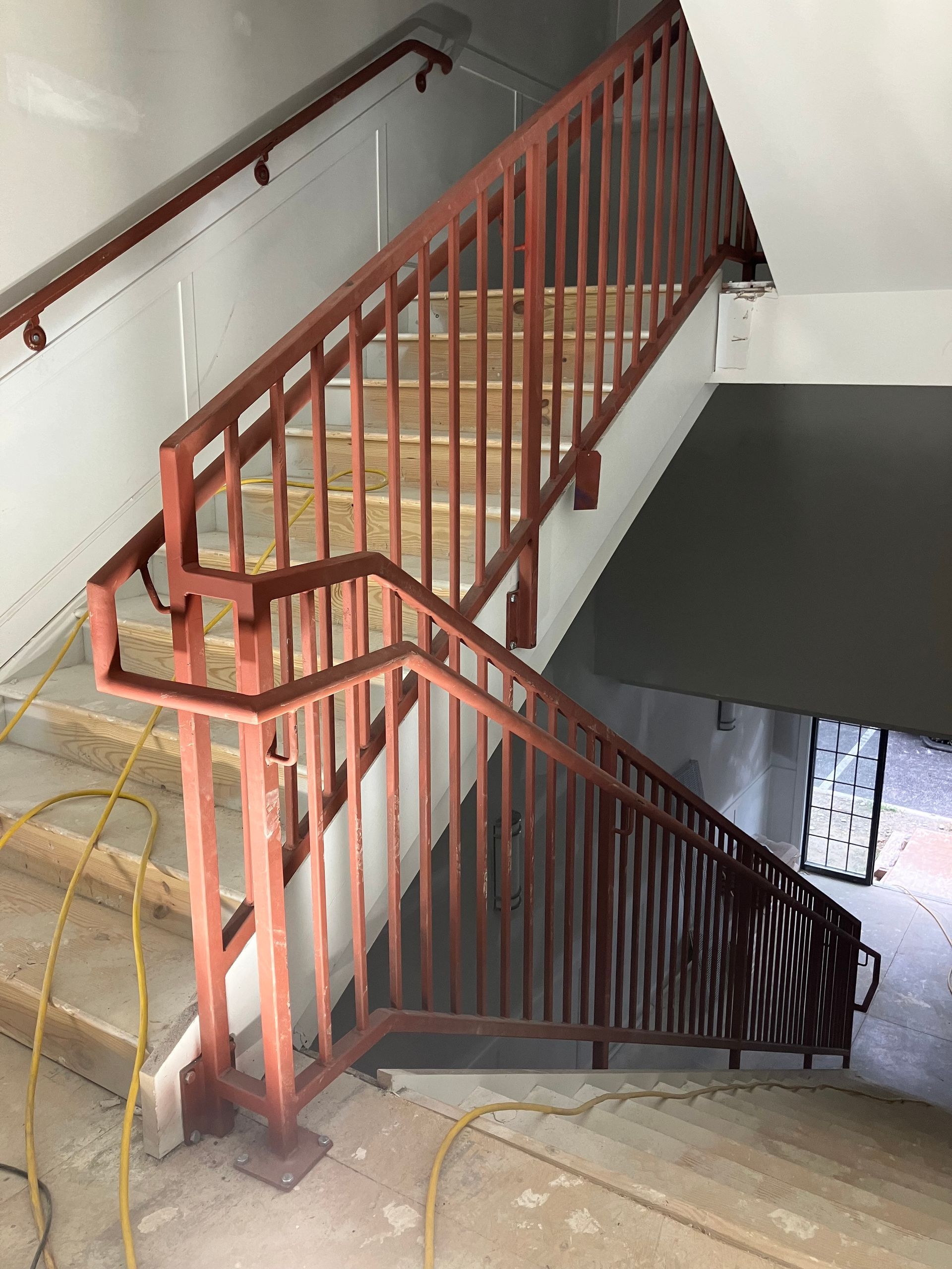 A red railing on a set of stairs in a building