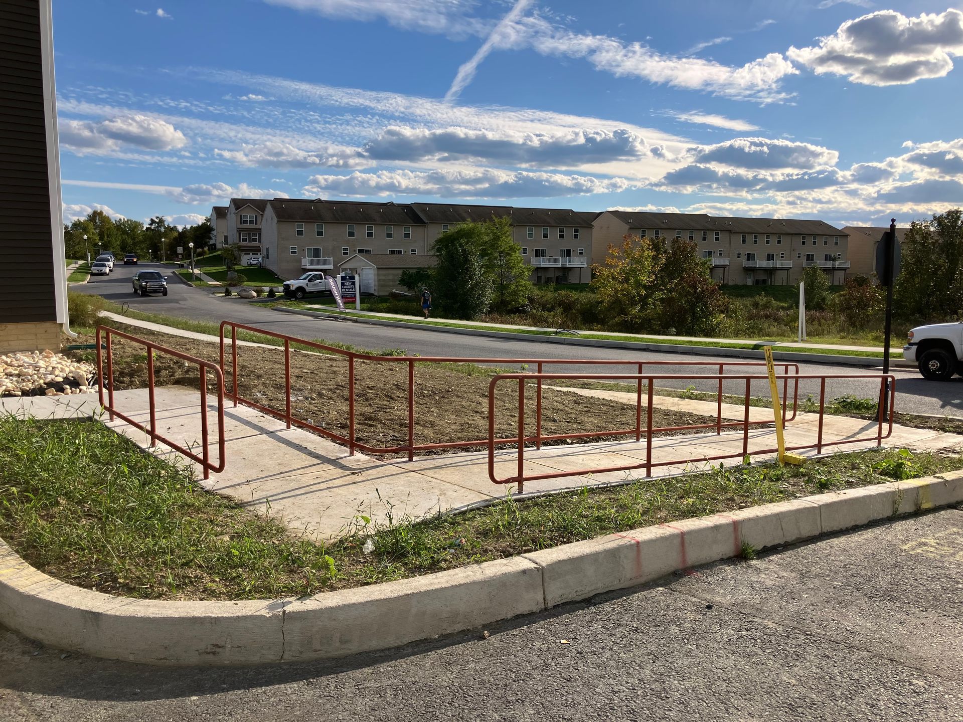 A white truck is parked on the side of the road in front of a building.