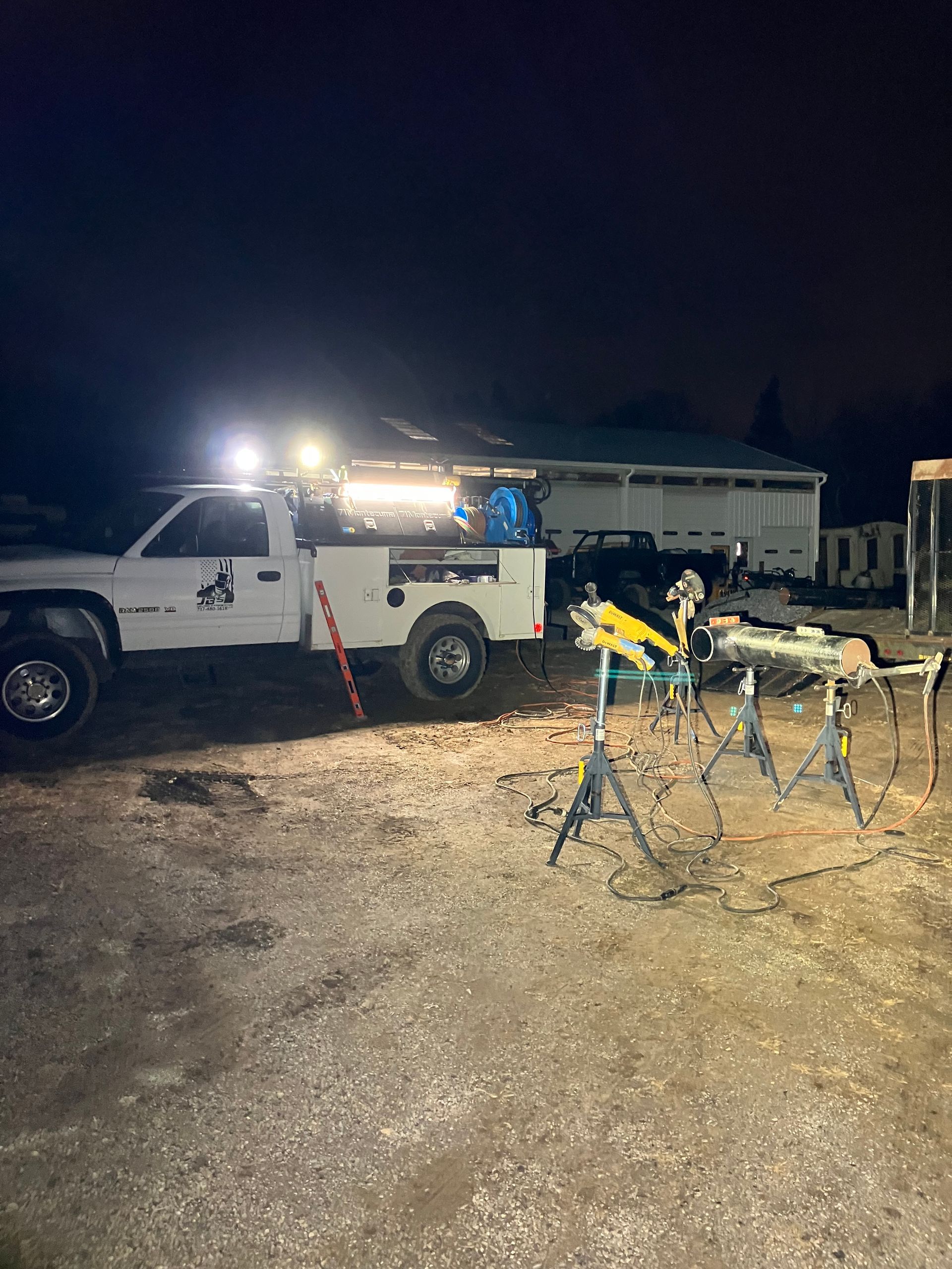 A white truck is parked in a parking lot at night.