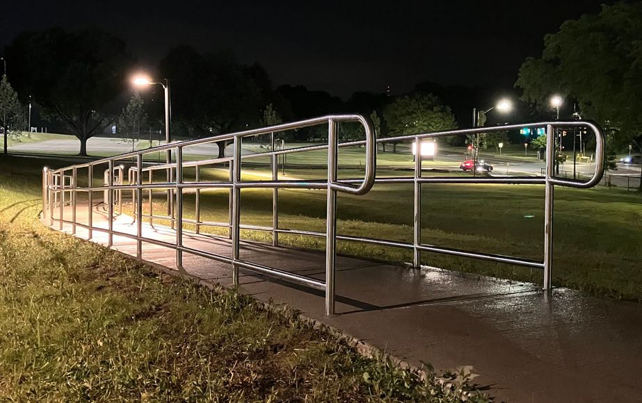 A handicapped ramp is lit up at night in a park.