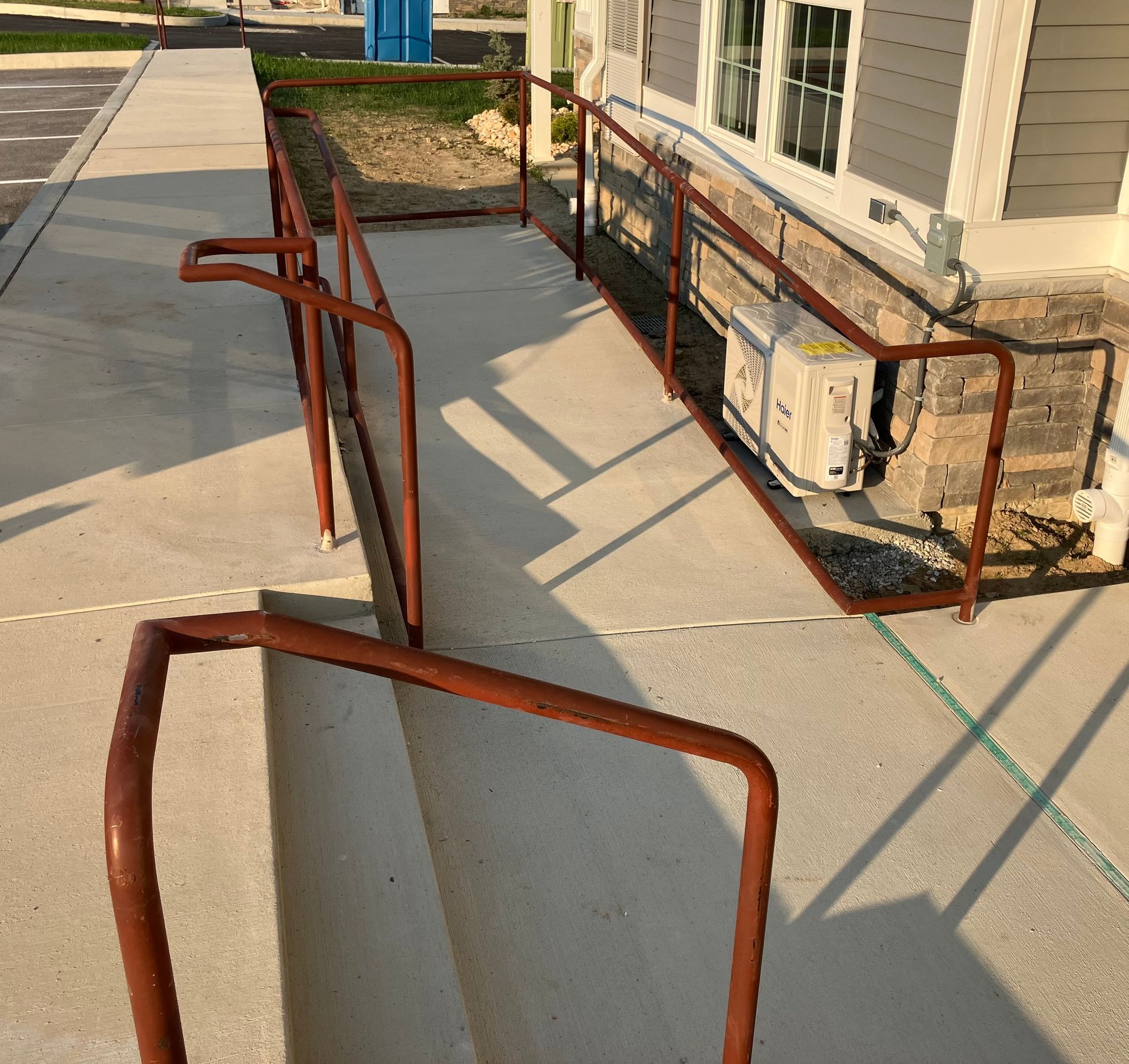 A ramp with a red railing leading to a house