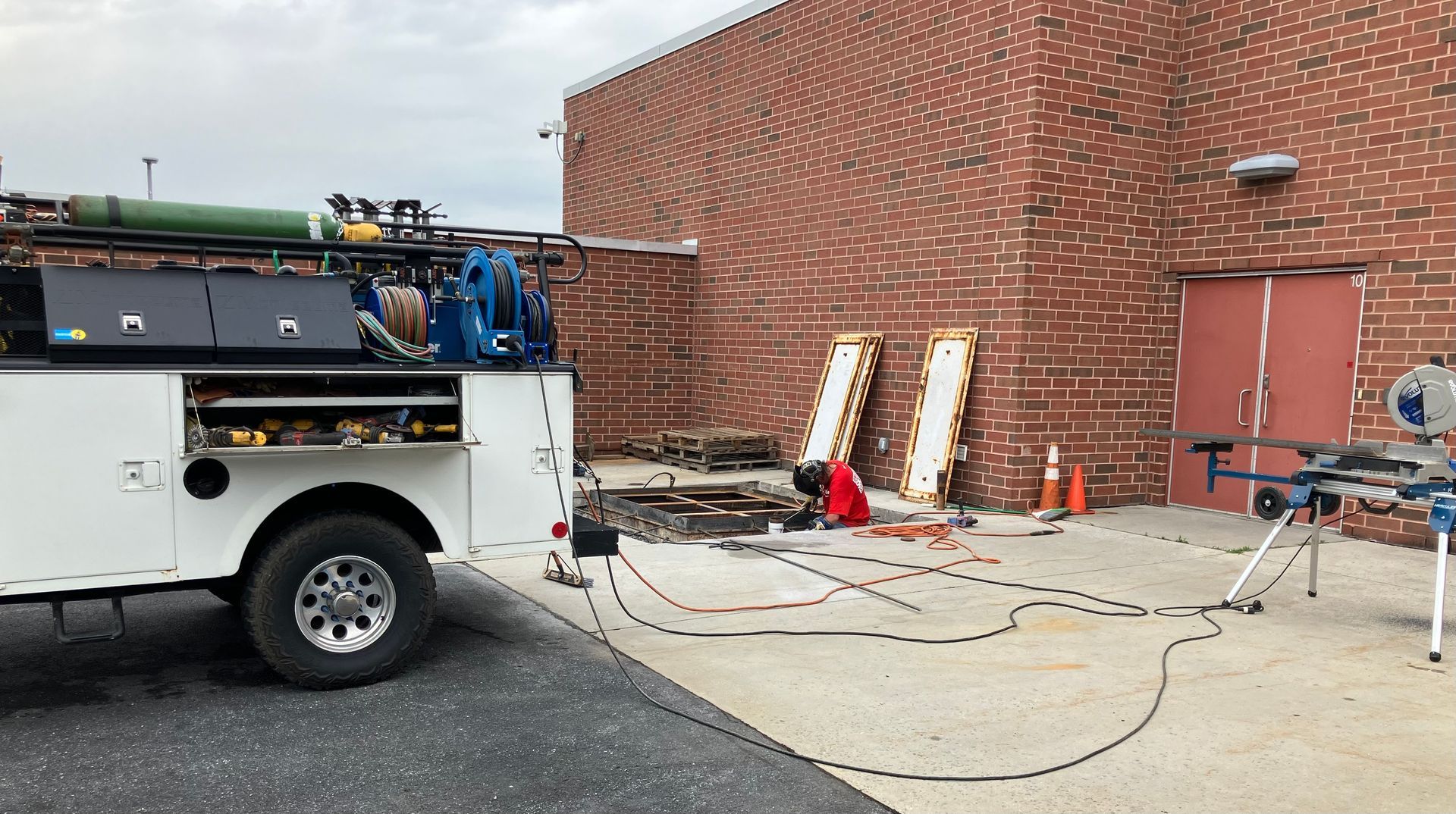 A white truck is parked in front of a brick building.
