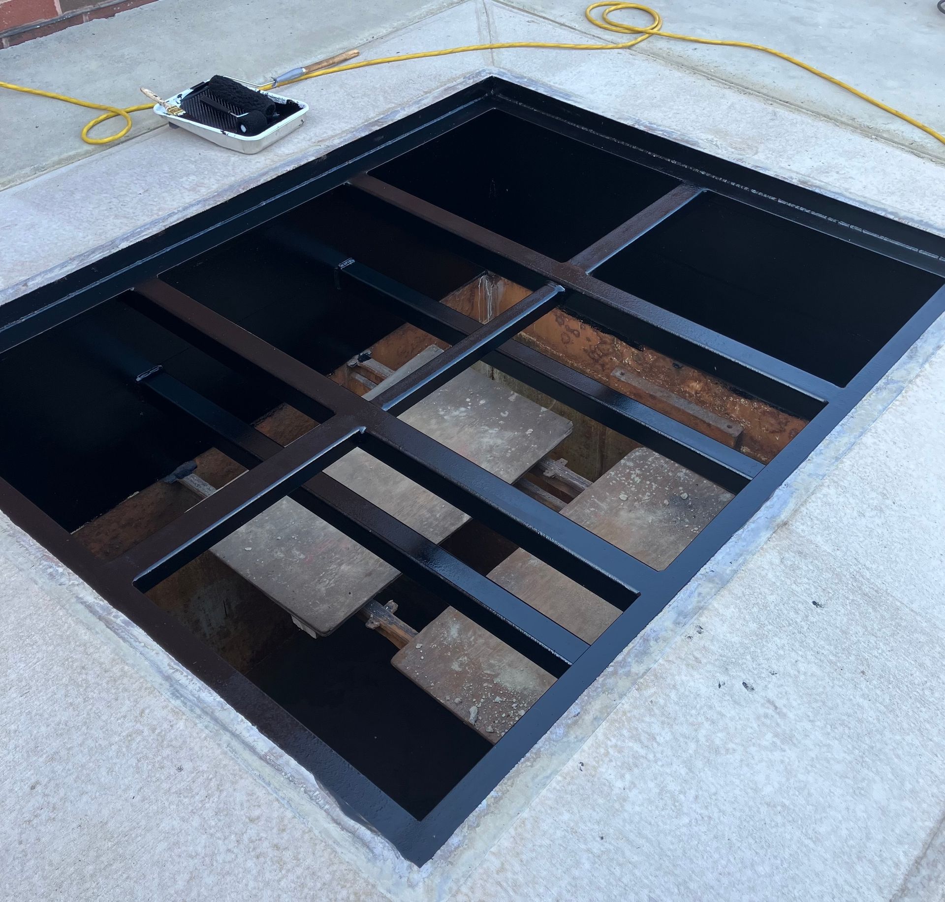 A hole in the ground with a metal frame around it