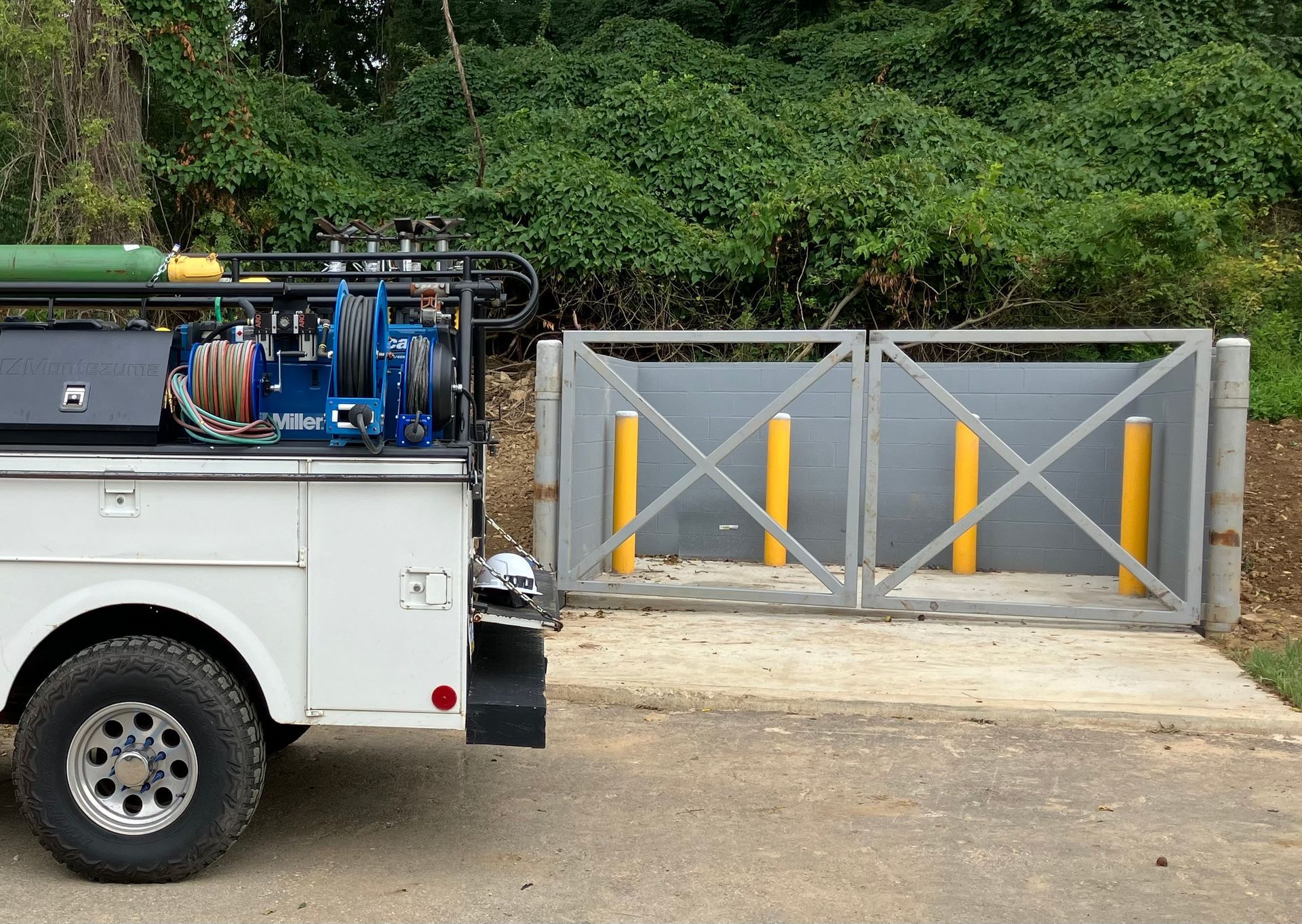 A white truck is parked in front of a gate