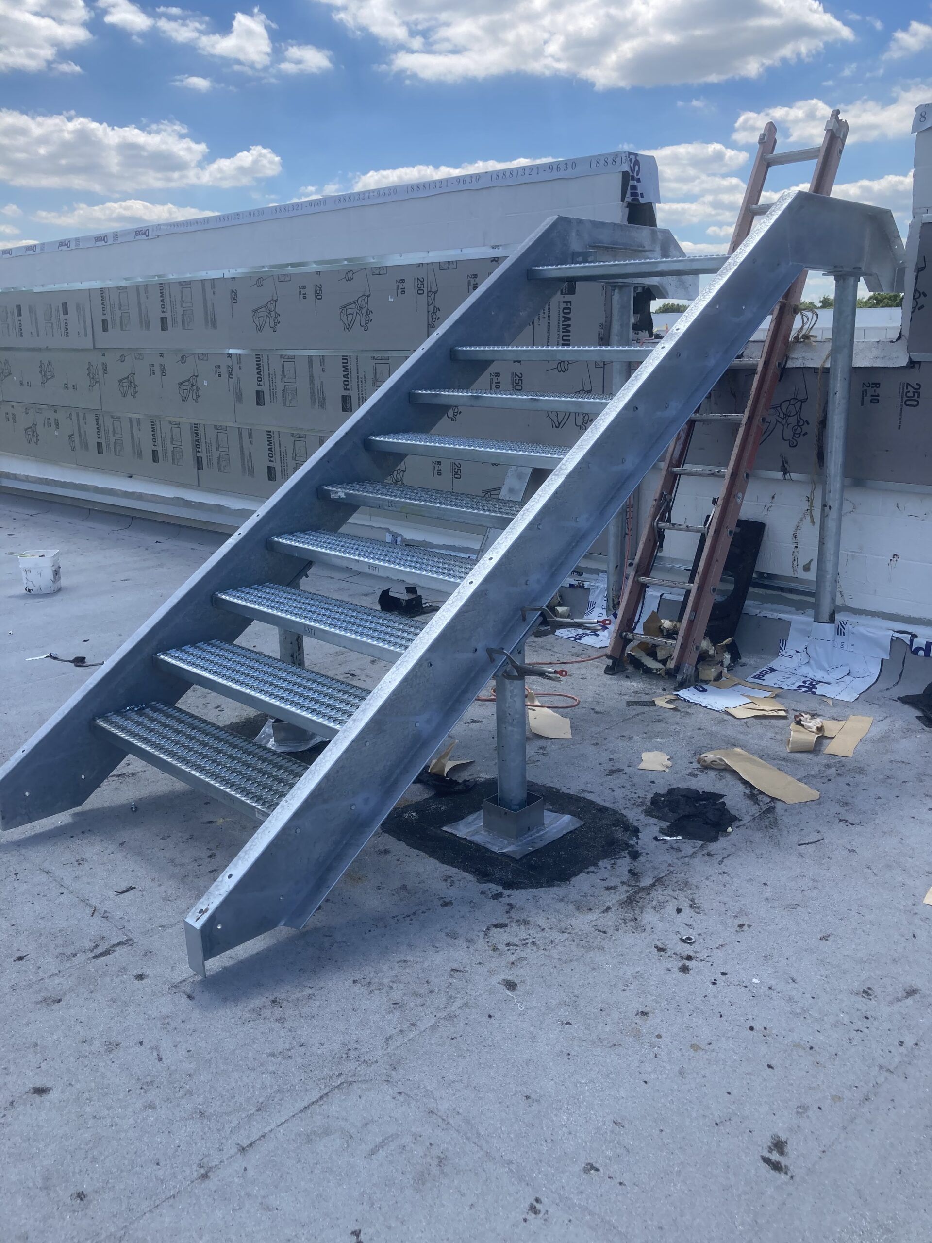 A metal staircase is sitting on top of a roof.