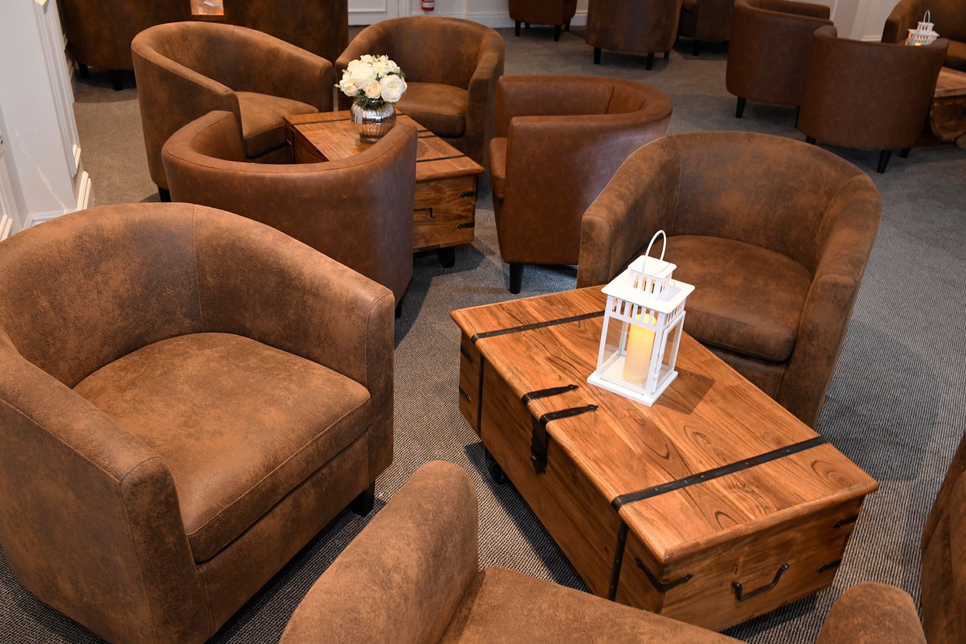 A living room filled with brown chairs and a wooden table.