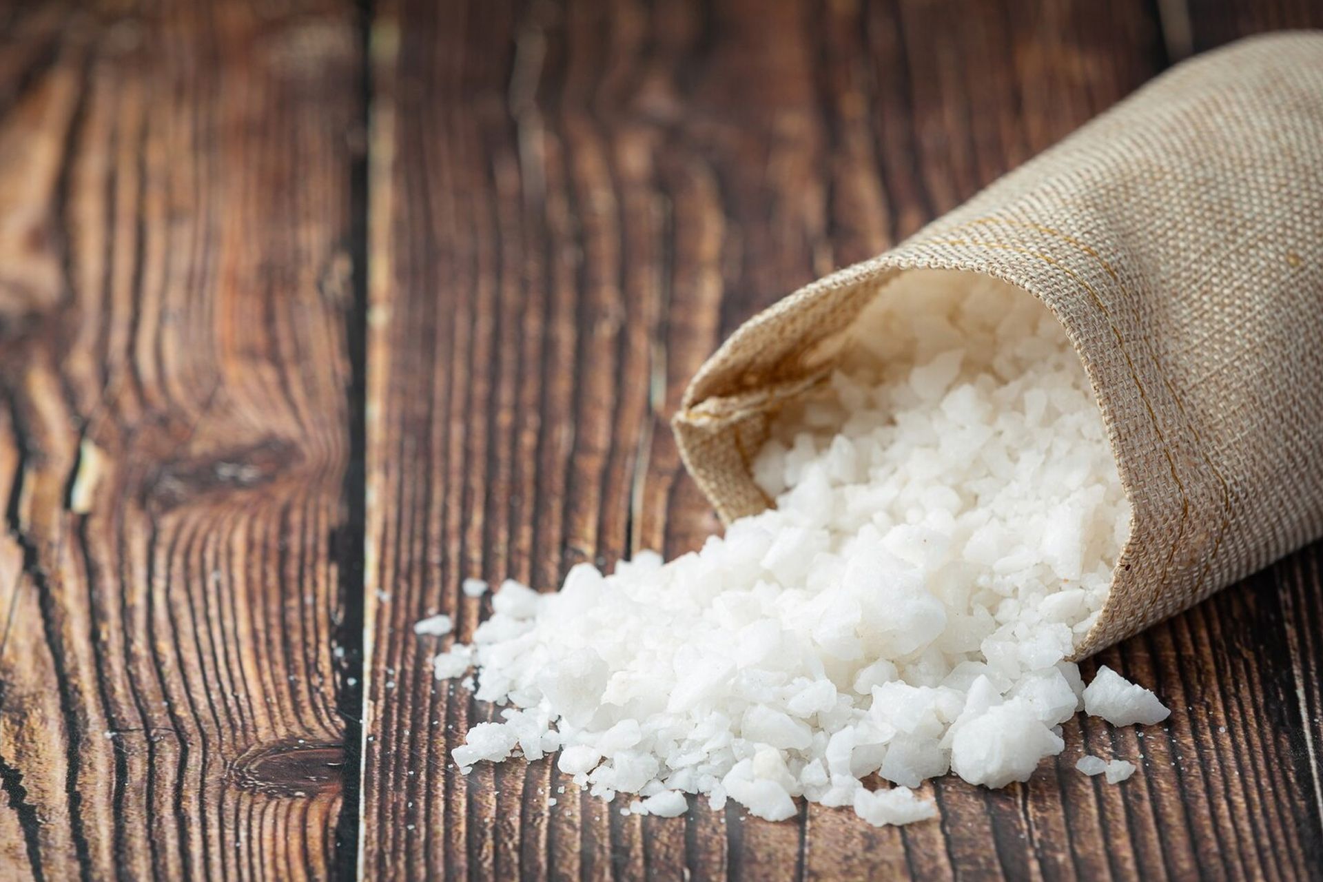Water filtration system with blue tanks, pipes, and control panel against a tiled wall.