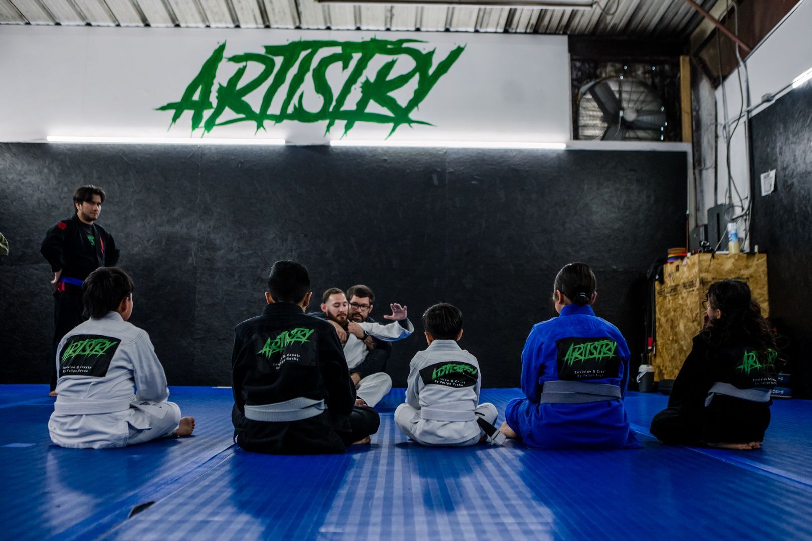 Adults and kids drilling Brazilian Jiu Jitsu at Artistry BJJ in Houston, TX, building fitness.