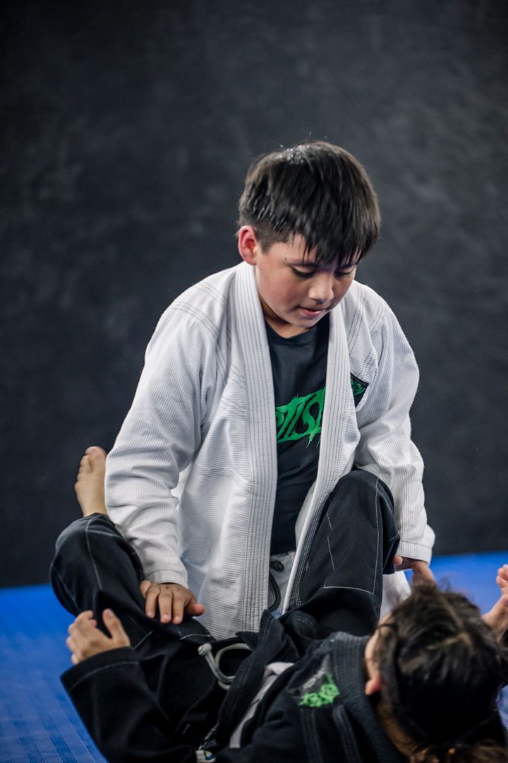 Kids practicing Youth Brazilian Jiu Jitsu at Artistry BJJ in Houston, Texas, building confidence and friendships.