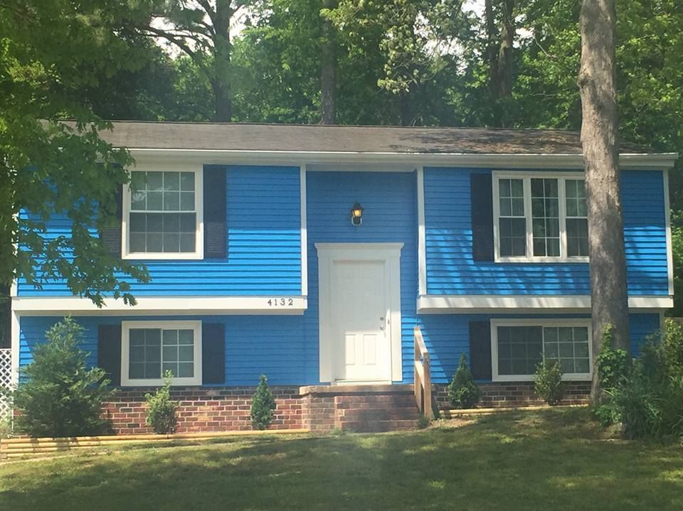 A blue house with white trim and black shutters