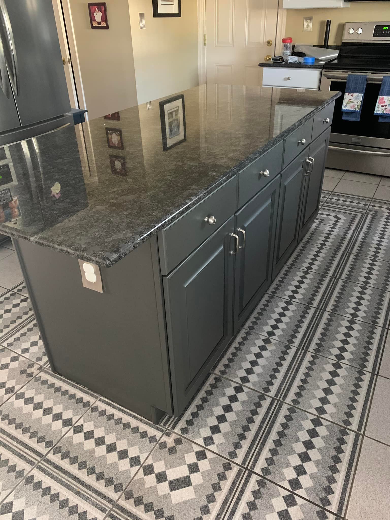 A kitchen with a large island and a rug on the floor.