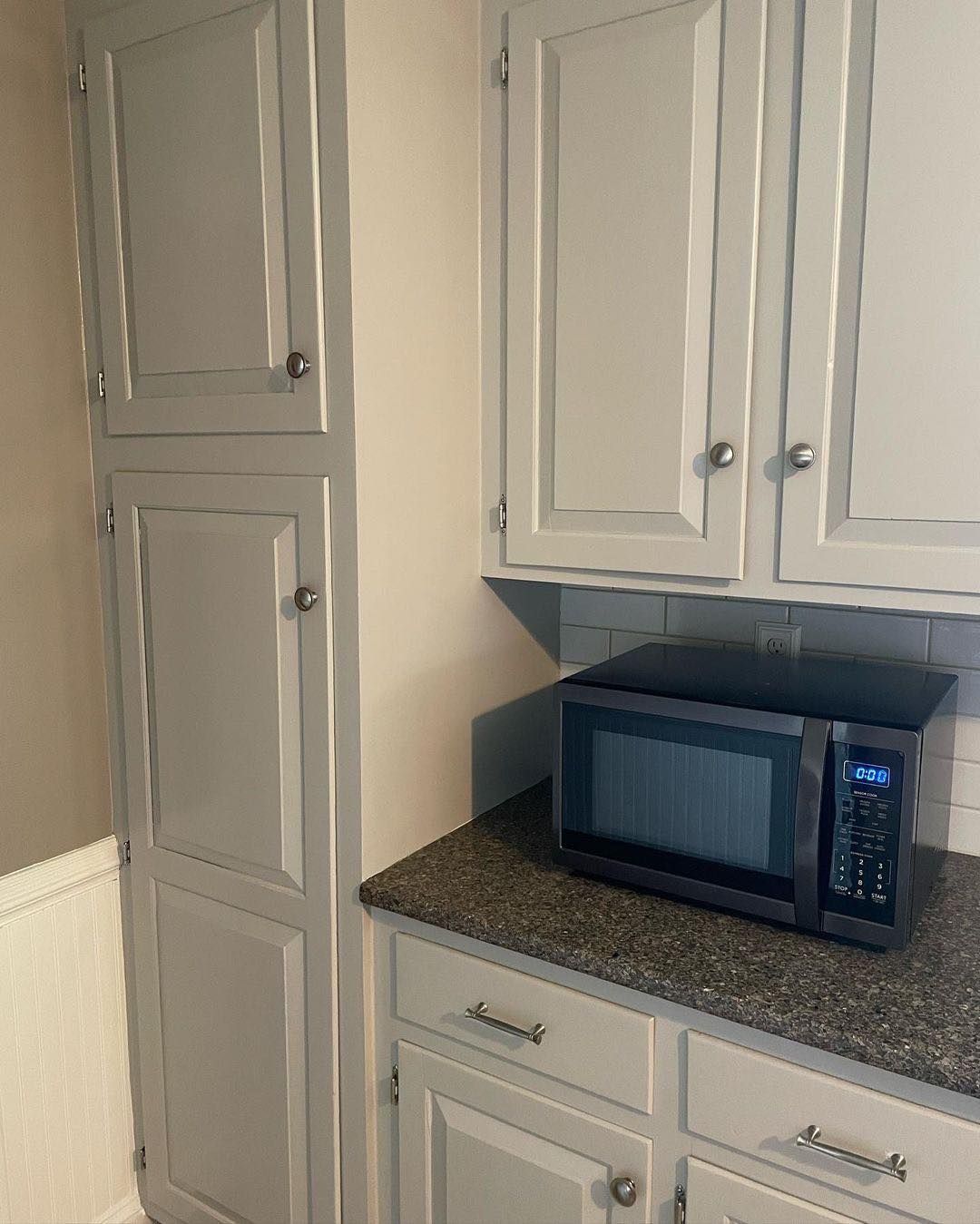 A microwave is sitting on a counter in a kitchen