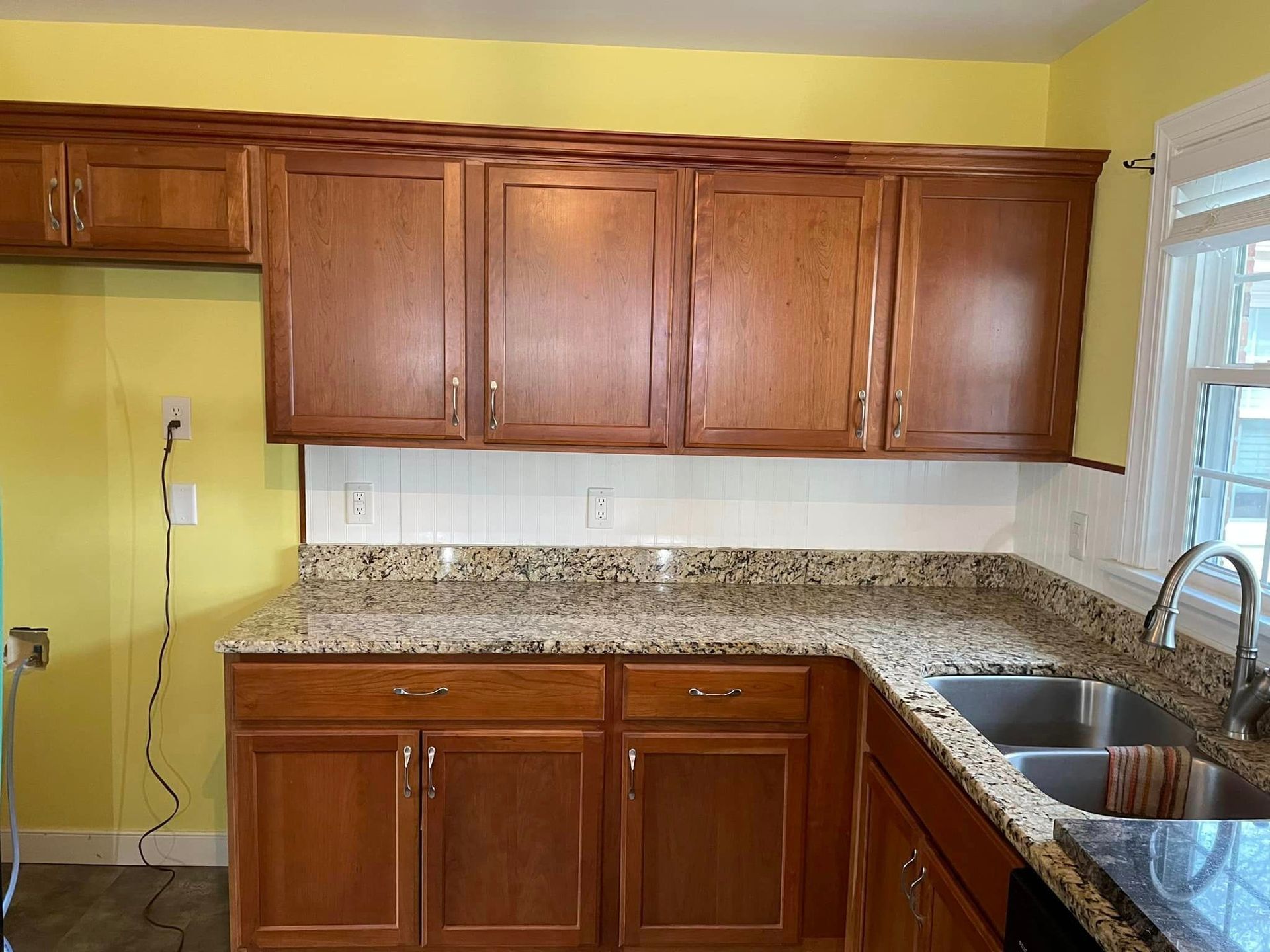 A kitchen with wooden cabinets and granite counter tops.